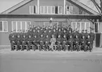 Elever och lärare vid vicekorpralskolan på F 3 Östgöta flygflottilj, 1940-1941. Grupporträtt framför byggnad.