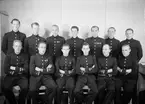 Elever vid furirskolan på F 3 Östgöta flygflottilj, 1942-1943. 13 stycken elever, från F 2 och F 5. Grupporträtt inomhus.