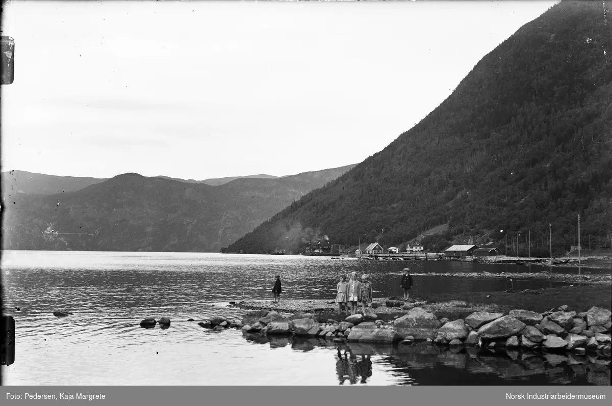 Barn ved Tinnsjøen. Utsikt mot Mæl fergeleie der Ammonia og Rjukanfos ligger til kai. Fyrlykt på fergeleie.