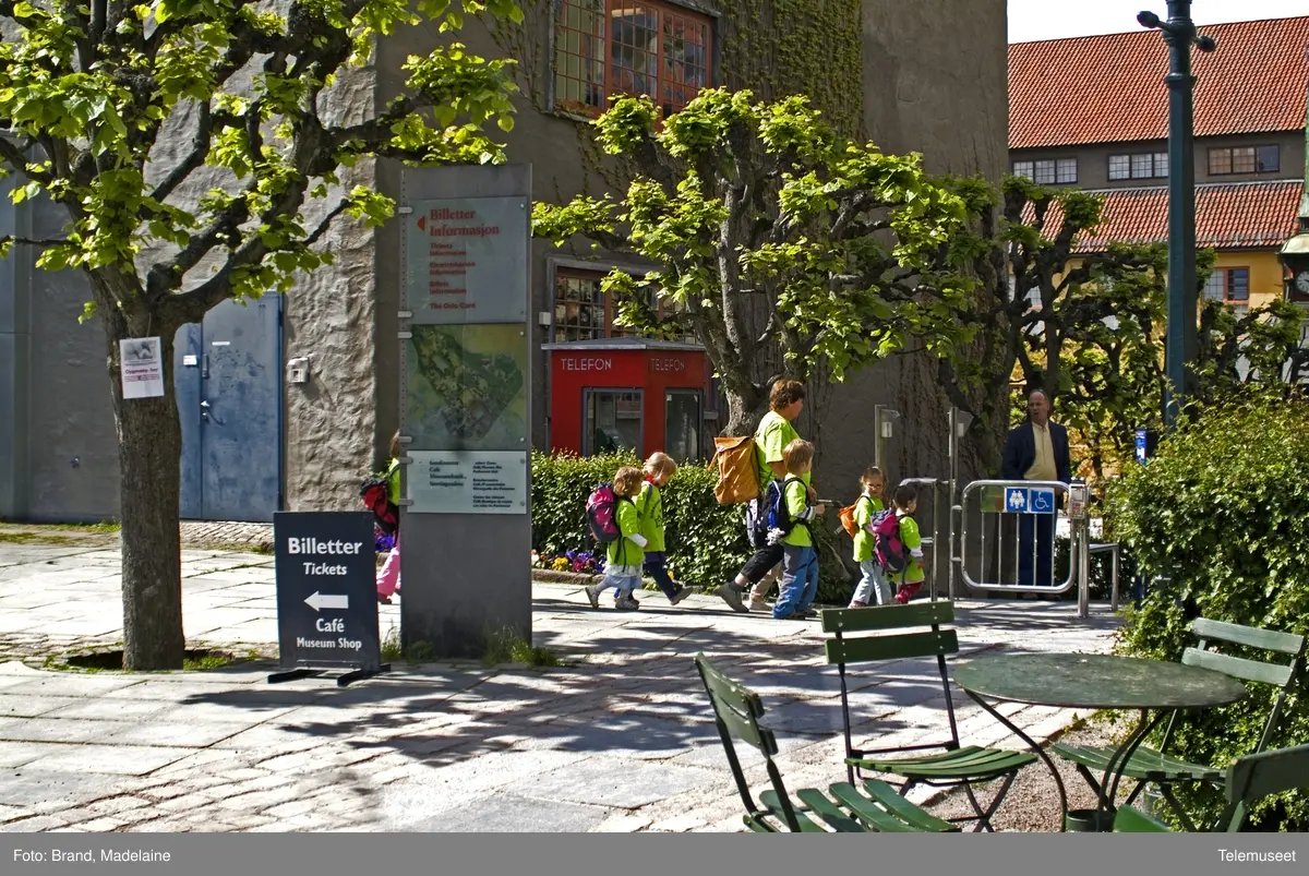 This is the story of how Norway’s most important conversation-space was designed by a young, freshly graduated man from Bergen.

“Norwegian architects are hereby invited…”
In the autumn of 1932, Oslo Telefonanlegginitiated an architectural competition. Finally, Oslo would get its own telephone booth. The city had had so called “talking-stations” from 1885, which in turn were overtaken by automatic telephones 
 only available at selected Narvesen kiosks. The state 
was of the opinion that now was the time to offer the public a better service; public telephone booths open 24/7, like the ones they already had in Sweden and England. But what would they look like, these new telephone booths? What considerations would it
 be necessary to take when designing it? The telegraph board developed a detailed list of demands and restraints: “The booth is intended to be placed outside on the streets and squares and need to be designed so that snow and ice does not hinder the opening and closing of the doors,” they wrote. “To prevent vandalism, theft, uncleanliness etc. inside the booth, it needs to be designed so that from all angles one may see what is going on in there.” Additionally, it would need to withstand storms and bad weather, and “preferably also being whipped by rain mixed with seawater” 

This was not all: The appearance would have to be «pleasing». The booth also needed to be movable, so that it could be taken in to be serviced at Telegrafverket’s main workshops. The reqired material was iron, and the surface was to be spray painted  preferably using car-body paint. There was a requirement for “a writing shelf, a pack shelf, and a suitable place for the telephone catalogue.” Also, there would need to be an illuminated TELEFON  sign, easily visible from all four angles. The total cost for each booth should not exceed 1000 kroner. The first prize for coming up with such a product was 800 kroner.

“Norwegianarchitects are hereby invited to partake in a competition for the design of a telephone booth…”  

The man with the solution
«At some point in 1932, Georg Fredrik sat at a party in Bergen. Maybe he felt a bit lost and forgotten as he often had throughout his life. He retreated to a quiet corner, took out a pencil and strted doodling on a matchbox.  According to my mother, this was how the telephone booth came into being.” In the book “Norges lille røde  historien om telefonkiosken,” Lars Fasting describes his father, the man who is far less known than the iconic architctural structure he left behind. Georg Fredrik Fasting was from Bergen, born into a family of working people and smallholders. One unusual facet of Georg Fredrik was that he was born without ears. His mother made sure he learnt to speak, read and write, 
ut Lars Fasting indicates that his father would seek refuge in drawing when the social challenges became too much to bear. And in the end drawing became his profession. In 1924 he secured a guarantor for a student loan, and started studying to become an a
rchitect at the NTH. Throughout the 1930s he entered several architectural competitions, with drafts produced, according to his son, “after work and in the late hours of the night.”

His efforts were not wasted. Out of 93 entries, with names such as “Flirt”, “Brrr”, “Ring” and “Amor”, the jury selected Fasting’s submission, “RIKS” as the new telephone booth: “The draft shows a strikingly simple solution to the task, technically as well as aesthetically well worked out.”

Taut and provident
Simple and aesthetc are the keywords here. Fasting had designed a booth pointing towards the future, and to modernism. Just how modern it was can be seen by comparing RIKS to the British telephone booth, also designed in the interwar-era. While the British version with it classicistic style is looking back to the heyday of the empire, Fasting’s booth is progressive and functionalistic. Like most Norwegian architects, Fasting broke with the classicistic style of architecture after the Stockholm-exhibition in 1930. “After it, almost all buildings erected in Norway until the German invasion in 1940, were in the functionalistic architectural style,” writes senior curator of architecture at the Norwegian National Museum, Ulf Grønvold, in the book, “Den lille røde”.“TheNorwegian booth is a piece of functionalistic architecture, an asymmetric composition with its roof slab overhanging the word TELEFON, in bold sans seraph lettering,”concludes Ulf Grønvold.

Fashionably red
And it was red. Fasting chose a colour which was part of the modern palette. “A bright red colour, but not as shiny as a signal red, the character of the colour places it among the fashionable colours within functionalism,” states paintings conservator and researcher in NIKU (Norwegian Institute for Cultural Heitage Research), Jon Brænne. In his opinion, Fasting went for visibility without making the booth stand out too much from its surroundings. The original colour was in use up to around 1950, when it changed to signal red. Towards the end of the 1970s the clour was again adjusted towards today’s orangey red.

The design, however, has not changed. RIKS is eighty years and still looks remarkably good. That’s what makes Fasting’s telephone booth a classic  even before it was added to DOCOMOMO’s list over moden icons of design. For Telenor, the telephone booth has served as a pathway into the hearts of the public. For many, Telenor (Televerket) was synonymous with exactly this telephone booth, because this was where one would go to place a call. Having a home
phone was not common until the 1980s. As such the red box became part of the Norwegian everyday and consciousness. The symbol- and publicity value of this is hard to evaluate, but in 2007 it was time to give honour where honour was due, Telenor, in consul
tation with the Directorate for Cultural Heritage, decided to preserve 100 telephone booths for all eternity.

And what about Georg Fredrik Fasting? What happened to him? At the age of 56 an entry in his diary states: «I CAN HEAR». As the first person in th world he had undergone an operation where he had ear canals constructed and eardrums fitted. For the rest of his life, the man behind Norway’s own telephone booth could answer the telephone himself.

Source: Norges lille røde historien om telefonkiosken (2007), issued by The Norwegian Telecom Museum and Telenor Cultural Heritage.