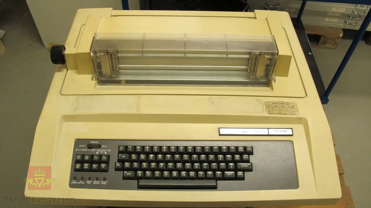Beige terminal på svart ramme. Terminalen er intakt men bærer preg av å ha stått en stund. Det er også flere klistremerker som har falt av eller har blitt fjernet. Tastaturet er grått med et lite instrumentpanel på venstre side der man kan stille inn print.

På undersiden av rammen sitter det sikringer og maskinens strømledning.

Toppen av terminalen kan åpnes for å skifte printerkassett og lignende. Ellers er terminalen i god stand.