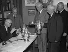 Intendent Nils Ålenius vid Upplandsmuseet besiktigar silverföremål,  i samband med silverutställning hos Uppsala Fabriks- och hantverksförening, Nedre Slottsgatan, Uppsala 1944