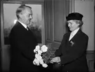 Landshövding Hilding Kjellman överlämnar blommor till f d landshövdingskan Elisabeth Linnér som nyss tagit emot medaljen Illis Quorum meruere labores
