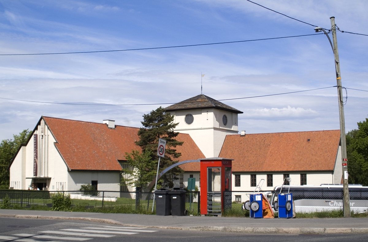 This is the story of how Norway’s most important conversation-space was designed by a young, freshly graduated man from Bergen.

“Norwegian architects are hereby invited…”
In the autumn of 1932, Oslo Telefonanlegginitiated an architectural competition. Finally, Oslo would get its own telephone booth. The city had had so called “talking-stations” from 1885, which in turn were overtaken by automatic telephones 
 only available at selected Narvesen kiosks. The state 
was of the opinion that now was the time to offer the public a better service; public telephone booths open 24/7, like the ones they already had in Sweden and England. But what would they look like, these new telephone booths? What considerations would it
 be necessary to take when designing it? The telegraph board developed a detailed list of demands and restraints: “The booth is intended to be placed outside on the streets and squares and need to be designed so that snow and ice does not hinder the opening and closing of the doors,” they wrote. “To prevent vandalism, theft, uncleanliness etc. inside the booth, it needs to be designed so that from all angles one may see what is going on in there.” Additionally, it would need to withstand storms and bad weather, and “preferably also being whipped by rain mixed with seawater” 

This was not all: The appearance would have to be «pleasing». The booth also needed to be movable, so that it could be taken in to be serviced at Telegrafverket’s main workshops. The reqired material was iron, and the surface was to be spray painted  preferably using car-body paint. There was a requirement for “a writing shelf, a pack shelf, and a suitable place for the telephone catalogue.” Also, there would need to be an illuminated TELEFON  sign, easily visible from all four angles. The total cost for each booth should not exceed 1000 kroner. The first prize for coming up with such a product was 800 kroner.

“Norwegianarchitects are hereby invited to partake in a competition for the design of a telephone booth…”  

The man with the solution
«At some point in 1932, Georg Fredrik sat at a party in Bergen. Maybe he felt a bit lost and forgotten as he often had throughout his life. He retreated to a quiet corner, took out a pencil and strted doodling on a matchbox.  According to my mother, this was how the telephone booth came into being.” In the book “Norges lille røde  historien om telefonkiosken,” Lars Fasting describes his father, the man who is far less known than the iconic architctural structure he left behind. Georg Fredrik Fasting was from Bergen, born into a family of working people and smallholders. One unusual facet of Georg Fredrik was that he was born without ears. His mother made sure he learnt to speak, read and write, 
ut Lars Fasting indicates that his father would seek refuge in drawing when the social challenges became too much to bear. And in the end drawing became his profession. In 1924 he secured a guarantor for a student loan, and started studying to become an a
rchitect at the NTH. Throughout the 1930s he entered several architectural competitions, with drafts produced, according to his son, “after work and in the late hours of the night.”

His efforts were not wasted. Out of 93 entries, with names such as “Flirt”, “Brrr”, “Ring” and “Amor”, the jury selected Fasting’s submission, “RIKS” as the new telephone booth: “The draft shows a strikingly simple solution to the task, technically as well as aesthetically well worked out.”

Taut and provident
Simple and aesthetc are the keywords here. Fasting had designed a booth pointing towards the future, and to modernism. Just how modern it was can be seen by comparing RIKS to the British telephone booth, also designed in the interwar-era. While the British version with it classicistic style is looking back to the heyday of the empire, Fasting’s booth is progressive and functionalistic. Like most Norwegian architects, Fasting broke with the classicistic style of architecture after the Stockholm-exhibition in 1930. “After it, almost all buildings erected in Norway until the German invasion in 1940, were in the functionalistic architectural style,” writes senior curator of architecture at the Norwegian National Museum, Ulf Grønvold, in the book, “Den lille røde”.“TheNorwegian booth is a piece of functionalistic architecture, an asymmetric composition with its roof slab overhanging the word TELEFON, in bold sans seraph lettering,”concludes Ulf Grønvold.

Fashionably red
And it was red. Fasting chose a colour which was part of the modern palette. “A bright red colour, but not as shiny as a signal red, the character of the colour places it among the fashionable colours within functionalism,” states paintings conservator and researcher in NIKU (Norwegian Institute for Cultural Heitage Research), Jon Brænne. In his opinion, Fasting went for visibility without making the booth stand out too much from its surroundings. The original colour was in use up to around 1950, when it changed to signal red. Towards the end of the 1970s the clour was again adjusted towards today’s orangey red.

The design, however, has not changed. RIKS is eighty years and still looks remarkably good. That’s what makes Fasting’s telephone booth a classic  even before it was added to DOCOMOMO’s list over moden icons of design. For Telenor, the telephone booth has served as a pathway into the hearts of the public. For many, Telenor (Televerket) was synonymous with exactly this telephone booth, because this was where one would go to place a call. Having a home
phone was not common until the 1980s. As such the red box became part of the Norwegian everyday and consciousness. The symbol- and publicity value of this is hard to evaluate, but in 2007 it was time to give honour where honour was due, Telenor, in consul
tation with the Directorate for Cultural Heritage, decided to preserve 100 telephone booths for all eternity.

And what about Georg Fredrik Fasting? What happened to him? At the age of 56 an entry in his diary states: «I CAN HEAR». As the first person in th world he had undergone an operation where he had ear canals constructed and eardrums fitted. For the rest of his life, the man behind Norway’s own telephone booth could answer the telephone himself.

Source: Norges lille røde historien om telefonkiosken (2007), issued by The Norwegian Telecom Museum and Telenor Cultural Heritage.