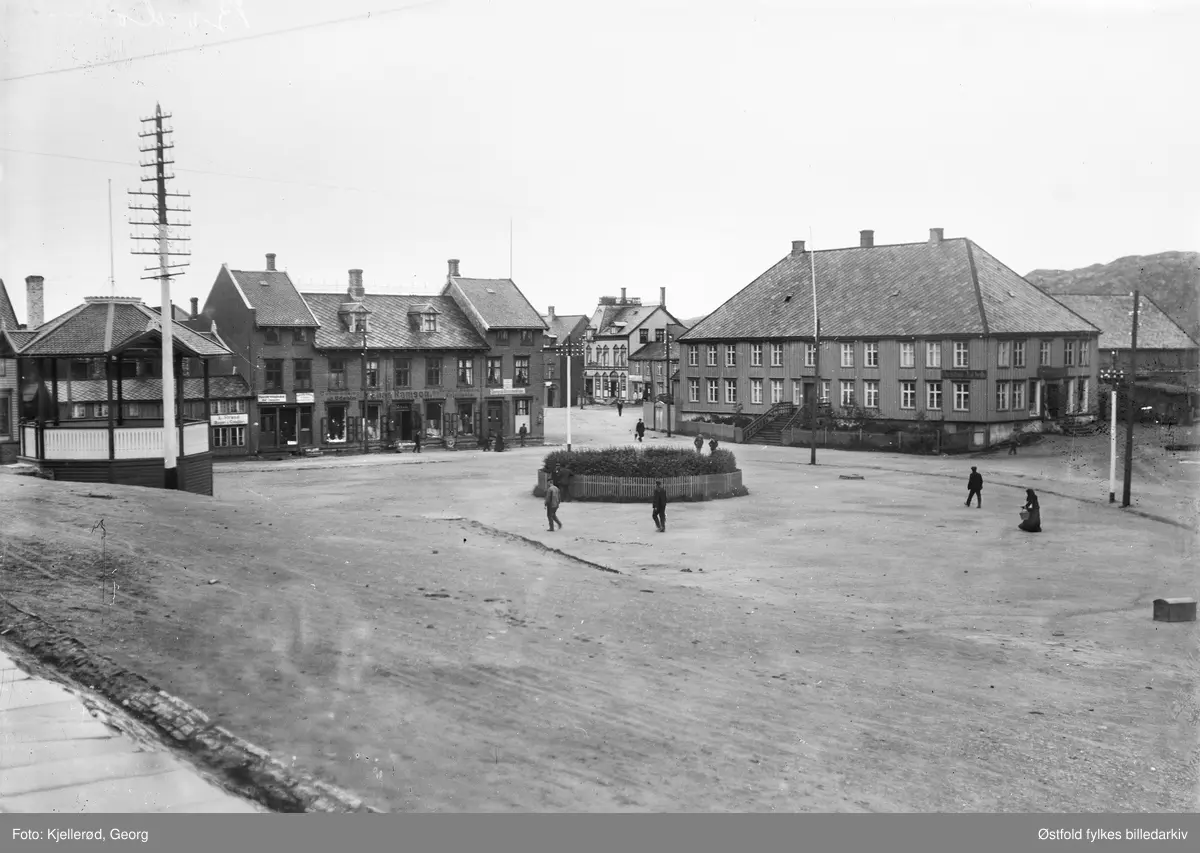 Bodø i Nordland, parti fra byens torg.  Huset til venstre  har påskrift Elias Ramson, forretning med adresse Torvet 2 i Bodø. 
Skilt: Dampskibsexpedition. Paviljong til venstre.