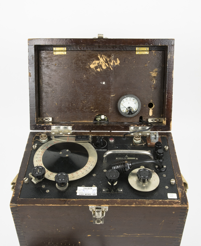 Frekvensmeter W1649. Antingen mäter den fram frekvens för tex Radiokommunikaton eller frekvens på en elektrisk signal på vilken man mäter antalet händelser (frekvens) per sekund. Detta mäts genom en sk Grind genom vilken en signal passerar med bestämd tid. Frekvensmetern har inkopplingsmljlighet av signalgenerator och med inställningar för den samma, det för effektiv samkörning. Frekvensmetern har även kristallinställning vilket ger en hög stabilitet för frekvensen. I frekvensmetern sitter även ett hjälpkraftsaggregat (power unit) av typ 633.