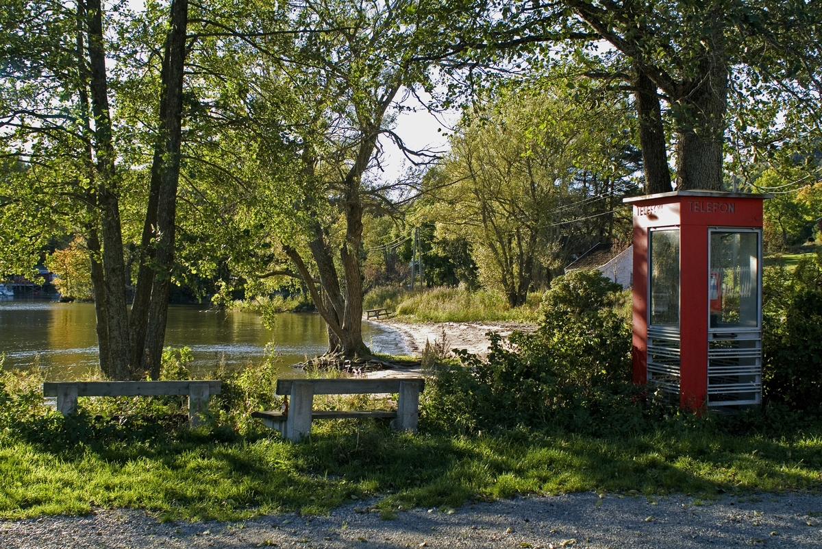 This is the story of how Norway’s most important conversation-space was designed by a young, freshly graduated man from Bergen.

“Norwegian architects are hereby invited…”
In the autumn of 1932, Oslo Telefonanlegginitiated an architectural competition. Finally, Oslo would get its own telephone booth. The city had had so called “talking-stations” from 1885, which in turn were overtaken by automatic telephones 
 only available at selected Narvesen kiosks. The state 
was of the opinion that now was the time to offer the public a better service; public telephone booths open 24/7, like the ones they already had in Sweden and England. But what would they look like, these new telephone booths? What considerations would it
 be necessary to take when designing it? The telegraph board developed a detailed list of demands and restraints: “The booth is intended to be placed outside on the streets and squares and need to be designed so that snow and ice does not hinder the opening and closing of the doors,” they wrote. “To prevent vandalism, theft, uncleanliness etc. inside the booth, it needs to be designed so that from all angles one may see what is going on in there.” Additionally, it would need to withstand storms and bad weather, and “preferably also being whipped by rain mixed with seawater” 

This was not all: The appearance would have to be «pleasing». The booth also needed to be movable, so that it could be taken in to be serviced at Telegrafverket’s main workshops. The reqired material was iron, and the surface was to be spray painted  preferably using car-body paint. There was a requirement for “a writing shelf, a pack shelf, and a suitable place for the telephone catalogue.” Also, there would need to be an illuminated TELEFON  sign, easily visible from all four angles. The total cost for each booth should not exceed 1000 kroner. The first prize for coming up with such a product was 800 kroner.

“Norwegianarchitects are hereby invited to partake in a competition for the design of a telephone booth…”  

The man with the solution
«At some point in 1932, Georg Fredrik sat at a party in Bergen. Maybe he felt a bit lost and forgotten as he often had throughout his life. He retreated to a quiet corner, took out a pencil and strted doodling on a matchbox.  According to my mother, this was how the telephone booth came into being.” In the book “Norges lille røde  historien om telefonkiosken,” Lars Fasting describes his father, the man who is far less known than the iconic architctural structure he left behind. Georg Fredrik Fasting was from Bergen, born into a family of working people and smallholders. One unusual facet of Georg Fredrik was that he was born without ears. His mother made sure he learnt to speak, read and write, 
ut Lars Fasting indicates that his father would seek refuge in drawing when the social challenges became too much to bear. And in the end drawing became his profession. In 1924 he secured a guarantor for a student loan, and started studying to become an a
rchitect at the NTH. Throughout the 1930s he entered several architectural competitions, with drafts produced, according to his son, “after work and in the late hours of the night.”

His efforts were not wasted. Out of 93 entries, with names such as “Flirt”, “Brrr”, “Ring” and “Amor”, the jury selected Fasting’s submission, “RIKS” as the new telephone booth: “The draft shows a strikingly simple solution to the task, technically as well as aesthetically well worked out.”

Taut and provident
Simple and aesthetc are the keywords here. Fasting had designed a booth pointing towards the future, and to modernism. Just how modern it was can be seen by comparing RIKS to the British telephone booth, also designed in the interwar-era. While the British version with it classicistic style is looking back to the heyday of the empire, Fasting’s booth is progressive and functionalistic. Like most Norwegian architects, Fasting broke with the classicistic style of architecture after the Stockholm-exhibition in 1930. “After it, almost all buildings erected in Norway until the German invasion in 1940, were in the functionalistic architectural style,” writes senior curator of architecture at the Norwegian National Museum, Ulf Grønvold, in the book, “Den lille røde”.“TheNorwegian booth is a piece of functionalistic architecture, an asymmetric composition with its roof slab overhanging the word TELEFON, in bold sans seraph lettering,”concludes Ulf Grønvold.

Fashionably red
And it was red. Fasting chose a colour which was part of the modern palette. “A bright red colour, but not as shiny as a signal red, the character of the colour places it among the fashionable colours within functionalism,” states paintings conservator and researcher in NIKU (Norwegian Institute for Cultural Heitage Research), Jon Brænne. In his opinion, Fasting went for visibility without making the booth stand out too much from its surroundings. The original colour was in use up to around 1950, when it changed to signal red. Towards the end of the 1970s the clour was again adjusted towards today’s orangey red.

The design, however, has not changed. RIKS is eighty years and still looks remarkably good. That’s what makes Fasting’s telephone booth a classic  even before it was added to DOCOMOMO’s list over moden icons of design. For Telenor, the telephone booth has served as a pathway into the hearts of the public. For many, Telenor (Televerket) was synonymous with exactly this telephone booth, because this was where one would go to place a call. Having a home
phone was not common until the 1980s. As such the red box became part of the Norwegian everyday and consciousness. The symbol- and publicity value of this is hard to evaluate, but in 2007 it was time to give honour where honour was due, Telenor, in consul
tation with the Directorate for Cultural Heritage, decided to preserve 100 telephone booths for all eternity.

And what about Georg Fredrik Fasting? What happened to him? At the age of 56 an entry in his diary states: «I CAN HEAR». As the first person in th world he had undergone an operation where he had ear canals constructed and eardrums fitted. For the rest of his life, the man behind Norway’s own telephone booth could answer the telephone himself.

Source: Norges lille røde historien om telefonkiosken (2007), issued by The Norwegian Telecom Museum and Telenor Cultural Heritage.