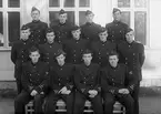 Elever vid korpralskolan för vapenmekaniker på F 3 Östgöta flygflottilj, 1944-1945. 13 elever, från F 2, F 3 och F 5. Grupporträtt framför byggnad.