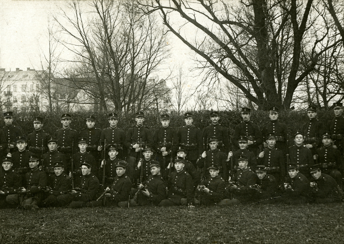 Gruppbild på infanterister. På deras mössor syns kompanimärket 12. Man kan se nummer 24 på axelklaffarna, vilket gör att detta är Norra Skånska infanteriregementet.