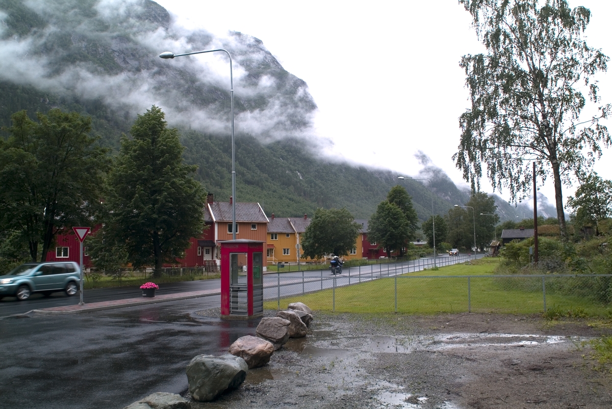 This is the story of how Norway’s most important conversation-space was designed by a young, freshly graduated man from Bergen.

“Norwegian architects are hereby invited…”
In the autumn of 1932, Oslo Telefonanlegginitiated an architectural competition. Finally, Oslo would get its own telephone booth. The city had had so called “talking-stations” from 1885, which in turn were overtaken by automatic telephones 
 only available at selected Narvesen kiosks. The state 
was of the opinion that now was the time to offer the public a better service; public telephone booths open 24/7, like the ones they already had in Sweden and England. But what would they look like, these new telephone booths? What considerations would it
 be necessary to take when designing it? The telegraph board developed a detailed list of demands and restraints: “The booth is intended to be placed outside on the streets and squares and need to be designed so that snow and ice does not hinder the opening and closing of the doors,” they wrote. “To prevent vandalism, theft, uncleanliness etc. inside the booth, it needs to be designed so that from all angles one may see what is going on in there.” Additionally, it would need to withstand storms and bad weather, and “preferably also being whipped by rain mixed with seawater” 

This was not all: The appearance would have to be «pleasing». The booth also needed to be movable, so that it could be taken in to be serviced at Telegrafverket’s main workshops. The reqired material was iron, and the surface was to be spray painted  preferably using car-body paint. There was a requirement for “a writing shelf, a pack shelf, and a suitable place for the telephone catalogue.” Also, there would need to be an illuminated TELEFON  sign, easily visible from all four angles. The total cost for each booth should not exceed 1000 kroner. The first prize for coming up with such a product was 800 kroner.

“Norwegianarchitects are hereby invited to partake in a competition for the design of a telephone booth…”  

The man with the solution
«At some point in 1932, Georg Fredrik sat at a party in Bergen. Maybe he felt a bit lost and forgotten as he often had throughout his life. He retreated to a quiet corner, took out a pencil and strted doodling on a matchbox.  According to my mother, this was how the telephone booth came into being.” In the book “Norges lille røde  historien om telefonkiosken,” Lars Fasting describes his father, the man who is far less known than the iconic architctural structure he left behind. Georg Fredrik Fasting was from Bergen, born into a family of working people and smallholders. One unusual facet of Georg Fredrik was that he was born without ears. His mother made sure he learnt to speak, read and write, 
ut Lars Fasting indicates that his father would seek refuge in drawing when the social challenges became too much to bear. And in the end drawing became his profession. In 1924 he secured a guarantor for a student loan, and started studying to become an a
rchitect at the NTH. Throughout the 1930s he entered several architectural competitions, with drafts produced, according to his son, “after work and in the late hours of the night.”

His efforts were not wasted. Out of 93 entries, with names such as “Flirt”, “Brrr”, “Ring” and “Amor”, the jury selected Fasting’s submission, “RIKS” as the new telephone booth: “The draft shows a strikingly simple solution to the task, technically as well as aesthetically well worked out.”

Taut and provident
Simple and aesthetc are the keywords here. Fasting had designed a booth pointing towards the future, and to modernism. Just how modern it was can be seen by comparing RIKS to the British telephone booth, also designed in the interwar-era. While the British version with it classicistic style is looking back to the heyday of the empire, Fasting’s booth is progressive and functionalistic. Like most Norwegian architects, Fasting broke with the classicistic style of architecture after the Stockholm-exhibition in 1930. “After it, almost all buildings erected in Norway until the German invasion in 1940, were in the functionalistic architectural style,” writes senior curator of architecture at the Norwegian National Museum, Ulf Grønvold, in the book, “Den lille røde”.“TheNorwegian booth is a piece of functionalistic architecture, an asymmetric composition with its roof slab overhanging the word TELEFON, in bold sans seraph lettering,”concludes Ulf Grønvold.

Fashionably red
And it was red. Fasting chose a colour which was part of the modern palette. “A bright red colour, but not as shiny as a signal red, the character of the colour places it among the fashionable colours within functionalism,” states paintings conservator and researcher in NIKU (Norwegian Institute for Cultural Heitage Research), Jon Brænne. In his opinion, Fasting went for visibility without making the booth stand out too much from its surroundings. The original colour was in use up to around 1950, when it changed to signal red. Towards the end of the 1970s the clour was again adjusted towards today’s orangey red.

The design, however, has not changed. RIKS is eighty years and still looks remarkably good. That’s what makes Fasting’s telephone booth a classic  even before it was added to DOCOMOMO’s list over moden icons of design. For Telenor, the telephone booth has served as a pathway into the hearts of the public. For many, Telenor (Televerket) was synonymous with exactly this telephone booth, because this was where one would go to place a call. Having a home
phone was not common until the 1980s. As such the red box became part of the Norwegian everyday and consciousness. The symbol- and publicity value of this is hard to evaluate, but in 2007 it was time to give honour where honour was due, Telenor, in consul
tation with the Directorate for Cultural Heritage, decided to preserve 100 telephone booths for all eternity.

And what about Georg Fredrik Fasting? What happened to him? At the age of 56 an entry in his diary states: «I CAN HEAR». As the first person in th world he had undergone an operation where he had ear canals constructed and eardrums fitted. For the rest of his life, the man behind Norway’s own telephone booth could answer the telephone himself.

Source: Norges lille røde historien om telefonkiosken (2007), issued by The Norwegian Telecom Museum and Telenor Cultural Heritage.