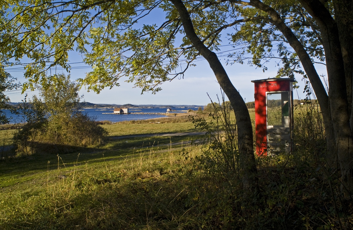 This is the story of how Norway’s most important conversation-space was designed by a young, freshly graduated man from Bergen.

“Norwegian architects are hereby invited…”
In the autumn of 1932, Oslo Telefonanlegginitiated an architectural competition. Finally, Oslo would get its own telephone booth. The city had had so called “talking-stations” from 1885, which in turn were overtaken by automatic telephones 
 only available at selected Narvesen kiosks. The state 
was of the opinion that now was the time to offer the public a better service; public telephone booths open 24/7, like the ones they already had in Sweden and England. But what would they look like, these new telephone booths? What considerations would it
 be necessary to take when designing it? The telegraph board developed a detailed list of demands and restraints: “The booth is intended to be placed outside on the streets and squares and need to be designed so that snow and ice does not hinder the opening and closing of the doors,” they wrote. “To prevent vandalism, theft, uncleanliness etc. inside the booth, it needs to be designed so that from all angles one may see what is going on in there.” Additionally, it would need to withstand storms and bad weather, and “preferably also being whipped by rain mixed with seawater” 

This was not all: The appearance would have to be «pleasing». The booth also needed to be movable, so that it could be taken in to be serviced at Telegrafverket’s main workshops. The reqired material was iron, and the surface was to be spray painted  preferably using car-body paint. There was a requirement for “a writing shelf, a pack shelf, and a suitable place for the telephone catalogue.” Also, there would need to be an illuminated TELEFON  sign, easily visible from all four angles. The total cost for each booth should not exceed 1000 kroner. The first prize for coming up with such a product was 800 kroner.

“Norwegianarchitects are hereby invited to partake in a competition for the design of a telephone booth…”  

The man with the solution
«At some point in 1932, Georg Fredrik sat at a party in Bergen. Maybe he felt a bit lost and forgotten as he often had throughout his life. He retreated to a quiet corner, took out a pencil and strted doodling on a matchbox.  According to my mother, this was how the telephone booth came into being.” In the book “Norges lille røde  historien om telefonkiosken,” Lars Fasting describes his father, the man who is far less known than the iconic architctural structure he left behind. Georg Fredrik Fasting was from Bergen, born into a family of working people and smallholders. One unusual facet of Georg Fredrik was that he was born without ears. His mother made sure he learnt to speak, read and write, 
ut Lars Fasting indicates that his father would seek refuge in drawing when the social challenges became too much to bear. And in the end drawing became his profession. In 1924 he secured a guarantor for a student loan, and started studying to become an a
rchitect at the NTH. Throughout the 1930s he entered several architectural competitions, with drafts produced, according to his son, “after work and in the late hours of the night.”

His efforts were not wasted. Out of 93 entries, with names such as “Flirt”, “Brrr”, “Ring” and “Amor”, the jury selected Fasting’s submission, “RIKS” as the new telephone booth: “The draft shows a strikingly simple solution to the task, technically as well as aesthetically well worked out.”

Taut and provident
Simple and aesthetc are the keywords here. Fasting had designed a booth pointing towards the future, and to modernism. Just how modern it was can be seen by comparing RIKS to the British telephone booth, also designed in the interwar-era. While the British version with it classicistic style is looking back to the heyday of the empire, Fasting’s booth is progressive and functionalistic. Like most Norwegian architects, Fasting broke with the classicistic style of architecture after the Stockholm-exhibition in 1930. “After it, almost all buildings erected in Norway until the German invasion in 1940, were in the functionalistic architectural style,” writes senior curator of architecture at the Norwegian National Museum, Ulf Grønvold, in the book, “Den lille røde”.“TheNorwegian booth is a piece of functionalistic architecture, an asymmetric composition with its roof slab overhanging the word TELEFON, in bold sans seraph lettering,”concludes Ulf Grønvold.

Fashionably red
And it was red. Fasting chose a colour which was part of the modern palette. “A bright red colour, but not as shiny as a signal red, the character of the colour places it among the fashionable colours within functionalism,” states paintings conservator and researcher in NIKU (Norwegian Institute for Cultural Heitage Research), Jon Brænne. In his opinion, Fasting went for visibility without making the booth stand out too much from its surroundings. The original colour was in use up to around 1950, when it changed to signal red. Towards the end of the 1970s the clour was again adjusted towards today’s orangey red.

The design, however, has not changed. RIKS is eighty years and still looks remarkably good. That’s what makes Fasting’s telephone booth a classic  even before it was added to DOCOMOMO’s list over moden icons of design. For Telenor, the telephone booth has served as a pathway into the hearts of the public. For many, Telenor (Televerket) was synonymous with exactly this telephone booth, because this was where one would go to place a call. Having a home
phone was not common until the 1980s. As such the red box became part of the Norwegian everyday and consciousness. The symbol- and publicity value of this is hard to evaluate, but in 2007 it was time to give honour where honour was due, Telenor, in consul
tation with the Directorate for Cultural Heritage, decided to preserve 100 telephone booths for all eternity.

And what about Georg Fredrik Fasting? What happened to him? At the age of 56 an entry in his diary states: «I CAN HEAR». As the first person in th world he had undergone an operation where he had ear canals constructed and eardrums fitted. For the rest of his life, the man behind Norway’s own telephone booth could answer the telephone himself.

Source: Norges lille røde historien om telefonkiosken (2007), issued by The Norwegian Telecom Museum and Telenor Cultural Heritage.