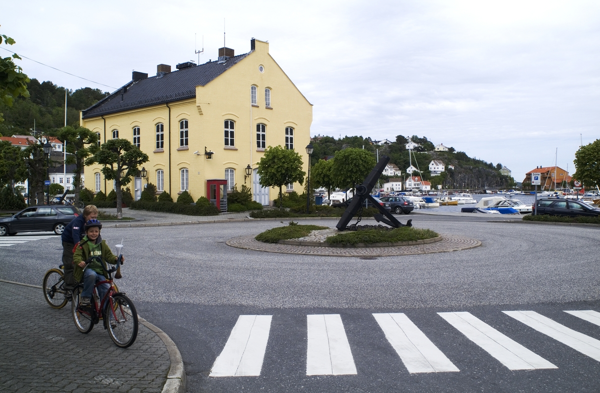 This is the story of how Norway’s most important conversation-space was designed by a young, freshly graduated man from Bergen.

“Norwegian architects are hereby invited…”
In the autumn of 1932, Oslo Telefonanlegginitiated an architectural competition. Finally, Oslo would get its own telephone booth. The city had had so called “talking-stations” from 1885, which in turn were overtaken by automatic telephones 
 only available at selected Narvesen kiosks. The state 
was of the opinion that now was the time to offer the public a better service; public telephone booths open 24/7, like the ones they already had in Sweden and England. But what would they look like, these new telephone booths? What considerations would it
 be necessary to take when designing it? The telegraph board developed a detailed list of demands and restraints: “The booth is intended to be placed outside on the streets and squares and need to be designed so that snow and ice does not hinder the opening and closing of the doors,” they wrote. “To prevent vandalism, theft, uncleanliness etc. inside the booth, it needs to be designed so that from all angles one may see what is going on in there.” Additionally, it would need to withstand storms and bad weather, and “preferably also being whipped by rain mixed with seawater” 

This was not all: The appearance would have to be «pleasing». The booth also needed to be movable, so that it could be taken in to be serviced at Telegrafverket’s main workshops. The reqired material was iron, and the surface was to be spray painted  preferably using car-body paint. There was a requirement for “a writing shelf, a pack shelf, and a suitable place for the telephone catalogue.” Also, there would need to be an illuminated TELEFON  sign, easily visible from all four angles. The total cost for each booth should not exceed 1000 kroner. The first prize for coming up with such a product was 800 kroner.

“Norwegianarchitects are hereby invited to partake in a competition for the design of a telephone booth…”  

The man with the solution
«At some point in 1932, Georg Fredrik sat at a party in Bergen. Maybe he felt a bit lost and forgotten as he often had throughout his life. He retreated to a quiet corner, took out a pencil and strted doodling on a matchbox.  According to my mother, this was how the telephone booth came into being.” In the book “Norges lille røde  historien om telefonkiosken,” Lars Fasting describes his father, the man who is far less known than the iconic architctural structure he left behind. Georg Fredrik Fasting was from Bergen, born into a family of working people and smallholders. One unusual facet of Georg Fredrik was that he was born without ears. His mother made sure he learnt to speak, read and write, 
ut Lars Fasting indicates that his father would seek refuge in drawing when the social challenges became too much to bear. And in the end drawing became his profession. In 1924 he secured a guarantor for a student loan, and started studying to become an a
rchitect at the NTH. Throughout the 1930s he entered several architectural competitions, with drafts produced, according to his son, “after work and in the late hours of the night.”

His efforts were not wasted. Out of 93 entries, with names such as “Flirt”, “Brrr”, “Ring” and “Amor”, the jury selected Fasting’s submission, “RIKS” as the new telephone booth: “The draft shows a strikingly simple solution to the task, technically as well as aesthetically well worked out.”

Taut and provident
Simple and aesthetc are the keywords here. Fasting had designed a booth pointing towards the future, and to modernism. Just how modern it was can be seen by comparing RIKS to the British telephone booth, also designed in the interwar-era. While the British version with it classicistic style is looking back to the heyday of the empire, Fasting’s booth is progressive and functionalistic. Like most Norwegian architects, Fasting broke with the classicistic style of architecture after the Stockholm-exhibition in 1930. “After it, almost all buildings erected in Norway until the German invasion in 1940, were in the functionalistic architectural style,” writes senior curator of architecture at the Norwegian National Museum, Ulf Grønvold, in the book, “Den lille røde”.“TheNorwegian booth is a piece of functionalistic architecture, an asymmetric composition with its roof slab overhanging the word TELEFON, in bold sans seraph lettering,”concludes Ulf Grønvold.

Fashionably red
And it was red. Fasting chose a colour which was part of the modern palette. “A bright red colour, but not as shiny as a signal red, the character of the colour places it among the fashionable colours within functionalism,” states paintings conservator and researcher in NIKU (Norwegian Institute for Cultural Heitage Research), Jon Brænne. In his opinion, Fasting went for visibility without making the booth stand out too much from its surroundings. The original colour was in use up to around 1950, when it changed to signal red. Towards the end of the 1970s the clour was again adjusted towards today’s orangey red.

The design, however, has not changed. RIKS is eighty years and still looks remarkably good. That’s what makes Fasting’s telephone booth a classic  even before it was added to DOCOMOMO’s list over moden icons of design. For Telenor, the telephone booth has served as a pathway into the hearts of the public. For many, Telenor (Televerket) was synonymous with exactly this telephone booth, because this was where one would go to place a call. Having a home
phone was not common until the 1980s. As such the red box became part of the Norwegian everyday and consciousness. The symbol- and publicity value of this is hard to evaluate, but in 2007 it was time to give honour where honour was due, Telenor, in consul
tation with the Directorate for Cultural Heritage, decided to preserve 100 telephone booths for all eternity.

And what about Georg Fredrik Fasting? What happened to him? At the age of 56 an entry in his diary states: «I CAN HEAR». As the first person in th world he had undergone an operation where he had ear canals constructed and eardrums fitted. For the rest of his life, the man behind Norway’s own telephone booth could answer the telephone himself.

Source: Norges lille røde historien om telefonkiosken (2007), issued by The Norwegian Telecom Museum and Telenor Cultural Heritage.
