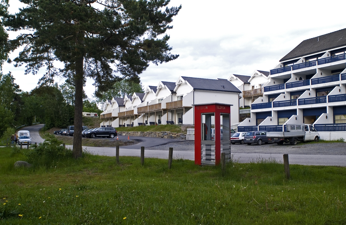 This is the story of how Norway’s most important conversation-space was designed by a young, freshly graduated man from Bergen.

“Norwegian architects are hereby invited…”
In the autumn of 1932, Oslo Telefonanlegginitiated an architectural competition. Finally, Oslo would get its own telephone booth. The city had had so called “talking-stations” from 1885, which in turn were overtaken by automatic telephones 
 only available at selected Narvesen kiosks. The state 
was of the opinion that now was the time to offer the public a better service; public telephone booths open 24/7, like the ones they already had in Sweden and England. But what would they look like, these new telephone booths? What considerations would it
 be necessary to take when designing it? The telegraph board developed a detailed list of demands and restraints: “The booth is intended to be placed outside on the streets and squares and need to be designed so that snow and ice does not hinder the opening and closing of the doors,” they wrote. “To prevent vandalism, theft, uncleanliness etc. inside the booth, it needs to be designed so that from all angles one may see what is going on in there.” Additionally, it would need to withstand storms and bad weather, and “preferably also being whipped by rain mixed with seawater” 

This was not all: The appearance would have to be «pleasing». The booth also needed to be movable, so that it could be taken in to be serviced at Telegrafverket’s main workshops. The reqired material was iron, and the surface was to be spray painted  preferably using car-body paint. There was a requirement for “a writing shelf, a pack shelf, and a suitable place for the telephone catalogue.” Also, there would need to be an illuminated TELEFON  sign, easily visible from all four angles. The total cost for each booth should not exceed 1000 kroner. The first prize for coming up with such a product was 800 kroner.

“Norwegianarchitects are hereby invited to partake in a competition for the design of a telephone booth…”  

The man with the solution
«At some point in 1932, Georg Fredrik sat at a party in Bergen. Maybe he felt a bit lost and forgotten as he often had throughout his life. He retreated to a quiet corner, took out a pencil and strted doodling on a matchbox.  According to my mother, this was how the telephone booth came into being.” In the book “Norges lille røde  historien om telefonkiosken,” Lars Fasting describes his father, the man who is far less known than the iconic architctural structure he left behind. Georg Fredrik Fasting was from Bergen, born into a family of working people and smallholders. One unusual facet of Georg Fredrik was that he was born without ears. His mother made sure he learnt to speak, read and write, 
ut Lars Fasting indicates that his father would seek refuge in drawing when the social challenges became too much to bear. And in the end drawing became his profession. In 1924 he secured a guarantor for a student loan, and started studying to become an a
rchitect at the NTH. Throughout the 1930s he entered several architectural competitions, with drafts produced, according to his son, “after work and in the late hours of the night.”

His efforts were not wasted. Out of 93 entries, with names such as “Flirt”, “Brrr”, “Ring” and “Amor”, the jury selected Fasting’s submission, “RIKS” as the new telephone booth: “The draft shows a strikingly simple solution to the task, technically as well as aesthetically well worked out.”

Taut and provident
Simple and aesthetc are the keywords here. Fasting had designed a booth pointing towards the future, and to modernism. Just how modern it was can be seen by comparing RIKS to the British telephone booth, also designed in the interwar-era. While the British version with it classicistic style is looking back to the heyday of the empire, Fasting’s booth is progressive and functionalistic. Like most Norwegian architects, Fasting broke with the classicistic style of architecture after the Stockholm-exhibition in 1930. “After it, almost all buildings erected in Norway until the German invasion in 1940, were in the functionalistic architectural style,” writes senior curator of architecture at the Norwegian National Museum, Ulf Grønvold, in the book, “Den lille røde”.“TheNorwegian booth is a piece of functionalistic architecture, an asymmetric composition with its roof slab overhanging the word TELEFON, in bold sans seraph lettering,”concludes Ulf Grønvold.

Fashionably red
And it was red. Fasting chose a colour which was part of the modern palette. “A bright red colour, but not as shiny as a signal red, the character of the colour places it among the fashionable colours within functionalism,” states paintings conservator and researcher in NIKU (Norwegian Institute for Cultural Heitage Research), Jon Brænne. In his opinion, Fasting went for visibility without making the booth stand out too much from its surroundings. The original colour was in use up to around 1950, when it changed to signal red. Towards the end of the 1970s the clour was again adjusted towards today’s orangey red.

The design, however, has not changed. RIKS is eighty years and still looks remarkably good. That’s what makes Fasting’s telephone booth a classic  even before it was added to DOCOMOMO’s list over moden icons of design. For Telenor, the telephone booth has served as a pathway into the hearts of the public. For many, Telenor (Televerket) was synonymous with exactly this telephone booth, because this was where one would go to place a call. Having a home
phone was not common until the 1980s. As such the red box became part of the Norwegian everyday and consciousness. The symbol- and publicity value of this is hard to evaluate, but in 2007 it was time to give honour where honour was due, Telenor, in consul
tation with the Directorate for Cultural Heritage, decided to preserve 100 telephone booths for all eternity.

And what about Georg Fredrik Fasting? What happened to him? At the age of 56 an entry in his diary states: «I CAN HEAR». As the first person in th world he had undergone an operation where he had ear canals constructed and eardrums fitted. For the rest of his life, the man behind Norway’s own telephone booth could answer the telephone himself.

Source: Norges lille røde historien om telefonkiosken (2007), issued by The Norwegian Telecom Museum and Telenor Cultural Heritage.