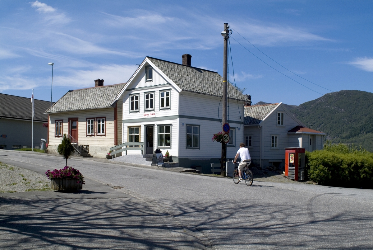 This is the story of how Norway’s most important conversation-space was designed by a young, freshly graduated man from Bergen.

“Norwegian architects are hereby invited…”
In the autumn of 1932, Oslo Telefonanlegginitiated an architectural competition. Finally, Oslo would get its own telephone booth. The city had had so called “talking-stations” from 1885, which in turn were overtaken by automatic telephones 
 only available at selected Narvesen kiosks. The state 
was of the opinion that now was the time to offer the public a better service; public telephone booths open 24/7, like the ones they already had in Sweden and England. But what would they look like, these new telephone booths? What considerations would it
 be necessary to take when designing it? The telegraph board developed a detailed list of demands and restraints: “The booth is intended to be placed outside on the streets and squares and need to be designed so that snow and ice does not hinder the opening and closing of the doors,” they wrote. “To prevent vandalism, theft, uncleanliness etc. inside the booth, it needs to be designed so that from all angles one may see what is going on in there.” Additionally, it would need to withstand storms and bad weather, and “preferably also being whipped by rain mixed with seawater” 

This was not all: The appearance would have to be «pleasing». The booth also needed to be movable, so that it could be taken in to be serviced at Telegrafverket’s main workshops. The reqired material was iron, and the surface was to be spray painted  preferably using car-body paint. There was a requirement for “a writing shelf, a pack shelf, and a suitable place for the telephone catalogue.” Also, there would need to be an illuminated TELEFON  sign, easily visible from all four angles. The total cost for each booth should not exceed 1000 kroner. The first prize for coming up with such a product was 800 kroner.

“Norwegianarchitects are hereby invited to partake in a competition for the design of a telephone booth…”  

The man with the solution
«At some point in 1932, Georg Fredrik sat at a party in Bergen. Maybe he felt a bit lost and forgotten as he often had throughout his life. He retreated to a quiet corner, took out a pencil and strted doodling on a matchbox.  According to my mother, this was how the telephone booth came into being.” In the book “Norges lille røde  historien om telefonkiosken,” Lars Fasting describes his father, the man who is far less known than the iconic architctural structure he left behind. Georg Fredrik Fasting was from Bergen, born into a family of working people and smallholders. One unusual facet of Georg Fredrik was that he was born without ears. His mother made sure he learnt to speak, read and write, 
ut Lars Fasting indicates that his father would seek refuge in drawing when the social challenges became too much to bear. And in the end drawing became his profession. In 1924 he secured a guarantor for a student loan, and started studying to become an a
rchitect at the NTH. Throughout the 1930s he entered several architectural competitions, with drafts produced, according to his son, “after work and in the late hours of the night.”

His efforts were not wasted. Out of 93 entries, with names such as “Flirt”, “Brrr”, “Ring” and “Amor”, the jury selected Fasting’s submission, “RIKS” as the new telephone booth: “The draft shows a strikingly simple solution to the task, technically as well as aesthetically well worked out.”

Taut and provident
Simple and aesthetc are the keywords here. Fasting had designed a booth pointing towards the future, and to modernism. Just how modern it was can be seen by comparing RIKS to the British telephone booth, also designed in the interwar-era. While the British version with it classicistic style is looking back to the heyday of the empire, Fasting’s booth is progressive and functionalistic. Like most Norwegian architects, Fasting broke with the classicistic style of architecture after the Stockholm-exhibition in 1930. “After it, almost all buildings erected in Norway until the German invasion in 1940, were in the functionalistic architectural style,” writes senior curator of architecture at the Norwegian National Museum, Ulf Grønvold, in the book, “Den lille røde”.“TheNorwegian booth is a piece of functionalistic architecture, an asymmetric composition with its roof slab overhanging the word TELEFON, in bold sans seraph lettering,”concludes Ulf Grønvold.

Fashionably red
And it was red. Fasting chose a colour which was part of the modern palette. “A bright red colour, but not as shiny as a signal red, the character of the colour places it among the fashionable colours within functionalism,” states paintings conservator and researcher in NIKU (Norwegian Institute for Cultural Heitage Research), Jon Brænne. In his opinion, Fasting went for visibility without making the booth stand out too much from its surroundings. The original colour was in use up to around 1950, when it changed to signal red. Towards the end of the 1970s the clour was again adjusted towards today’s orangey red.

The design, however, has not changed. RIKS is eighty years and still looks remarkably good. That’s what makes Fasting’s telephone booth a classic  even before it was added to DOCOMOMO’s list over moden icons of design. For Telenor, the telephone booth has served as a pathway into the hearts of the public. For many, Telenor (Televerket) was synonymous with exactly this telephone booth, because this was where one would go to place a call. Having a home
phone was not common until the 1980s. As such the red box became part of the Norwegian everyday and consciousness. The symbol- and publicity value of this is hard to evaluate, but in 2007 it was time to give honour where honour was due, Telenor, in consul
tation with the Directorate for Cultural Heritage, decided to preserve 100 telephone booths for all eternity.

And what about Georg Fredrik Fasting? What happened to him? At the age of 56 an entry in his diary states: «I CAN HEAR». As the first person in th world he had undergone an operation where he had ear canals constructed and eardrums fitted. For the rest of his life, the man behind Norway’s own telephone booth could answer the telephone himself.

Source: Norges lille røde historien om telefonkiosken (2007), issued by The Norwegian Telecom Museum and Telenor Cultural Heritage.