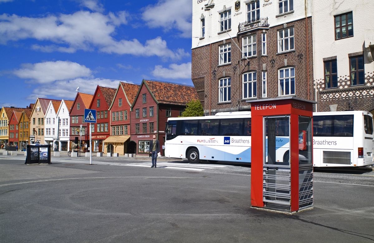 This is the story of how Norway’s most important conversation-space was designed by a young, freshly graduated man from Bergen.

“Norwegian architects are hereby invited…”
In the autumn of 1932, Oslo Telefonanlegginitiated an architectural competition. Finally, Oslo would get its own telephone booth. The city had had so called “talking-stations” from 1885, which in turn were overtaken by automatic telephones 
 only available at selected Narvesen kiosks. The state 
was of the opinion that now was the time to offer the public a better service; public telephone booths open 24/7, like the ones they already had in Sweden and England. But what would they look like, these new telephone booths? What considerations would it
 be necessary to take when designing it? The telegraph board developed a detailed list of demands and restraints: “The booth is intended to be placed outside on the streets and squares and need to be designed so that snow and ice does not hinder the opening and closing of the doors,” they wrote. “To prevent vandalism, theft, uncleanliness etc. inside the booth, it needs to be designed so that from all angles one may see what is going on in there.” Additionally, it would need to withstand storms and bad weather, and “preferably also being whipped by rain mixed with seawater” 

This was not all: The appearance would have to be «pleasing». The booth also needed to be movable, so that it could be taken in to be serviced at Telegrafverket’s main workshops. The reqired material was iron, and the surface was to be spray painted  preferably using car-body paint. There was a requirement for “a writing shelf, a pack shelf, and a suitable place for the telephone catalogue.” Also, there would need to be an illuminated TELEFON  sign, easily visible from all four angles. The total cost for each booth should not exceed 1000 kroner. The first prize for coming up with such a product was 800 kroner.

“Norwegianarchitects are hereby invited to partake in a competition for the design of a telephone booth…”  

The man with the solution
«At some point in 1932, Georg Fredrik sat at a party in Bergen. Maybe he felt a bit lost and forgotten as he often had throughout his life. He retreated to a quiet corner, took out a pencil and strted doodling on a matchbox.  According to my mother, this was how the telephone booth came into being.” In the book “Norges lille røde  historien om telefonkiosken,” Lars Fasting describes his father, the man who is far less known than the iconic architctural structure he left behind. Georg Fredrik Fasting was from Bergen, born into a family of working people and smallholders. One unusual facet of Georg Fredrik was that he was born without ears. His mother made sure he learnt to speak, read and write, 
ut Lars Fasting indicates that his father would seek refuge in drawing when the social challenges became too much to bear. And in the end drawing became his profession. In 1924 he secured a guarantor for a student loan, and started studying to become an a
rchitect at the NTH. Throughout the 1930s he entered several architectural competitions, with drafts produced, according to his son, “after work and in the late hours of the night.”

His efforts were not wasted. Out of 93 entries, with names such as “Flirt”, “Brrr”, “Ring” and “Amor”, the jury selected Fasting’s submission, “RIKS” as the new telephone booth: “The draft shows a strikingly simple solution to the task, technically as well as aesthetically well worked out.”

Taut and provident
Simple and aesthetc are the keywords here. Fasting had designed a booth pointing towards the future, and to modernism. Just how modern it was can be seen by comparing RIKS to the British telephone booth, also designed in the interwar-era. While the British version with it classicistic style is looking back to the heyday of the empire, Fasting’s booth is progressive and functionalistic. Like most Norwegian architects, Fasting broke with the classicistic style of architecture after the Stockholm-exhibition in 1930. “After it, almost all buildings erected in Norway until the German invasion in 1940, were in the functionalistic architectural style,” writes senior curator of architecture at the Norwegian National Museum, Ulf Grønvold, in the book, “Den lille røde”.“TheNorwegian booth is a piece of functionalistic architecture, an asymmetric composition with its roof slab overhanging the word TELEFON, in bold sans seraph lettering,”concludes Ulf Grønvold.

Fashionably red
And it was red. Fasting chose a colour which was part of the modern palette. “A bright red colour, but not as shiny as a signal red, the character of the colour places it among the fashionable colours within functionalism,” states paintings conservator and researcher in NIKU (Norwegian Institute for Cultural Heitage Research), Jon Brænne. In his opinion, Fasting went for visibility without making the booth stand out too much from its surroundings. The original colour was in use up to around 1950, when it changed to signal red. Towards the end of the 1970s the clour was again adjusted towards today’s orangey red.

The design, however, has not changed. RIKS is eighty years and still looks remarkably good. That’s what makes Fasting’s telephone booth a classic  even before it was added to DOCOMOMO’s list over moden icons of design. For Telenor, the telephone booth has served as a pathway into the hearts of the public. For many, Telenor (Televerket) was synonymous with exactly this telephone booth, because this was where one would go to place a call. Having a home
phone was not common until the 1980s. As such the red box became part of the Norwegian everyday and consciousness. The symbol- and publicity value of this is hard to evaluate, but in 2007 it was time to give honour where honour was due, Telenor, in consul
tation with the Directorate for Cultural Heritage, decided to preserve 100 telephone booths for all eternity.

And what about Georg Fredrik Fasting? What happened to him? At the age of 56 an entry in his diary states: «I CAN HEAR». As the first person in th world he had undergone an operation where he had ear canals constructed and eardrums fitted. For the rest of his life, the man behind Norway’s own telephone booth could answer the telephone himself.

Source: Norges lille røde historien om telefonkiosken (2007), issued by The Norwegian Telecom Museum and Telenor Cultural Heritage.