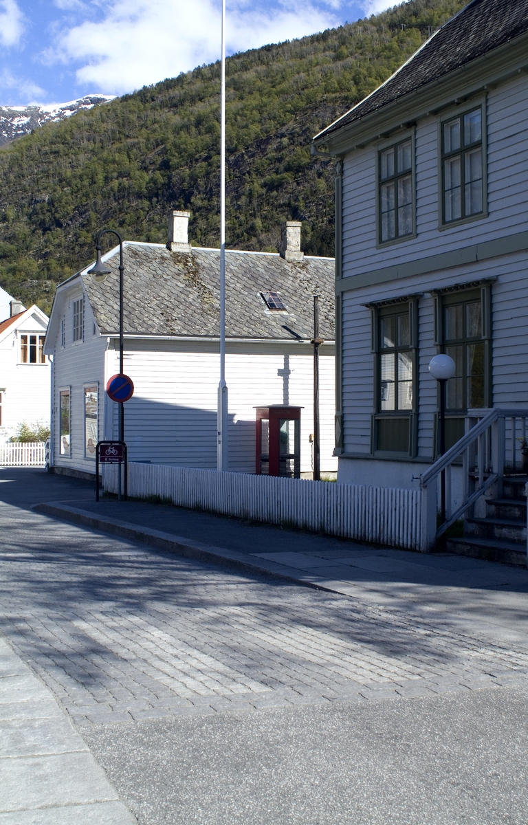 This is the story of how Norway’s most important conversation-space was designed by a young, freshly graduated man from Bergen.

“Norwegian architects are hereby invited…”
In the autumn of 1932, Oslo Telefonanlegginitiated an architectural competition. Finally, Oslo would get its own telephone booth. The city had had so called “talking-stations” from 1885, which in turn were overtaken by automatic telephones 
 only available at selected Narvesen kiosks. The state 
was of the opinion that now was the time to offer the public a better service; public telephone booths open 24/7, like the ones they already had in Sweden and England. But what would they look like, these new telephone booths? What considerations would it
 be necessary to take when designing it? The telegraph board developed a detailed list of demands and restraints: “The booth is intended to be placed outside on the streets and squares and need to be designed so that snow and ice does not hinder the opening and closing of the doors,” they wrote. “To prevent vandalism, theft, uncleanliness etc. inside the booth, it needs to be designed so that from all angles one may see what is going on in there.” Additionally, it would need to withstand storms and bad weather, and “preferably also being whipped by rain mixed with seawater” 

This was not all: The appearance would have to be «pleasing». The booth also needed to be movable, so that it could be taken in to be serviced at Telegrafverket’s main workshops. The reqired material was iron, and the surface was to be spray painted  preferably using car-body paint. There was a requirement for “a writing shelf, a pack shelf, and a suitable place for the telephone catalogue.” Also, there would need to be an illuminated TELEFON  sign, easily visible from all four angles. The total cost for each booth should not exceed 1000 kroner. The first prize for coming up with such a product was 800 kroner.

“Norwegianarchitects are hereby invited to partake in a competition for the design of a telephone booth…”  

The man with the solution
«At some point in 1932, Georg Fredrik sat at a party in Bergen. Maybe he felt a bit lost and forgotten as he often had throughout his life. He retreated to a quiet corner, took out a pencil and strted doodling on a matchbox.  According to my mother, this was how the telephone booth came into being.” In the book “Norges lille røde  historien om telefonkiosken,” Lars Fasting describes his father, the man who is far less known than the iconic architctural structure he left behind. Georg Fredrik Fasting was from Bergen, born into a family of working people and smallholders. One unusual facet of Georg Fredrik was that he was born without ears. His mother made sure he learnt to speak, read and write, 
ut Lars Fasting indicates that his father would seek refuge in drawing when the social challenges became too much to bear. And in the end drawing became his profession. In 1924 he secured a guarantor for a student loan, and started studying to become an a
rchitect at the NTH. Throughout the 1930s he entered several architectural competitions, with drafts produced, according to his son, “after work and in the late hours of the night.”

His efforts were not wasted. Out of 93 entries, with names such as “Flirt”, “Brrr”, “Ring” and “Amor”, the jury selected Fasting’s submission, “RIKS” as the new telephone booth: “The draft shows a strikingly simple solution to the task, technically as well as aesthetically well worked out.”

Taut and provident
Simple and aesthetc are the keywords here. Fasting had designed a booth pointing towards the future, and to modernism. Just how modern it was can be seen by comparing RIKS to the British telephone booth, also designed in the interwar-era. While the British version with it classicistic style is looking back to the heyday of the empire, Fasting’s booth is progressive and functionalistic. Like most Norwegian architects, Fasting broke with the classicistic style of architecture after the Stockholm-exhibition in 1930. “After it, almost all buildings erected in Norway until the German invasion in 1940, were in the functionalistic architectural style,” writes senior curator of architecture at the Norwegian National Museum, Ulf Grønvold, in the book, “Den lille røde”.“TheNorwegian booth is a piece of functionalistic architecture, an asymmetric composition with its roof slab overhanging the word TELEFON, in bold sans seraph lettering,”concludes Ulf Grønvold.

Fashionably red
And it was red. Fasting chose a colour which was part of the modern palette. “A bright red colour, but not as shiny as a signal red, the character of the colour places it among the fashionable colours within functionalism,” states paintings conservator and researcher in NIKU (Norwegian Institute for Cultural Heitage Research), Jon Brænne. In his opinion, Fasting went for visibility without making the booth stand out too much from its surroundings. The original colour was in use up to around 1950, when it changed to signal red. Towards the end of the 1970s the clour was again adjusted towards today’s orangey red.

The design, however, has not changed. RIKS is eighty years and still looks remarkably good. That’s what makes Fasting’s telephone booth a classic  even before it was added to DOCOMOMO’s list over moden icons of design. For Telenor, the telephone booth has served as a pathway into the hearts of the public. For many, Telenor (Televerket) was synonymous with exactly this telephone booth, because this was where one would go to place a call. Having a home
phone was not common until the 1980s. As such the red box became part of the Norwegian everyday and consciousness. The symbol- and publicity value of this is hard to evaluate, but in 2007 it was time to give honour where honour was due, Telenor, in consul
tation with the Directorate for Cultural Heritage, decided to preserve 100 telephone booths for all eternity.

And what about Georg Fredrik Fasting? What happened to him? At the age of 56 an entry in his diary states: «I CAN HEAR». As the first person in th world he had undergone an operation where he had ear canals constructed and eardrums fitted. For the rest of his life, the man behind Norway’s own telephone booth could answer the telephone himself.

Source: Norges lille røde historien om telefonkiosken (2007), issued by The Norwegian Telecom Museum and Telenor Cultural Heritage.