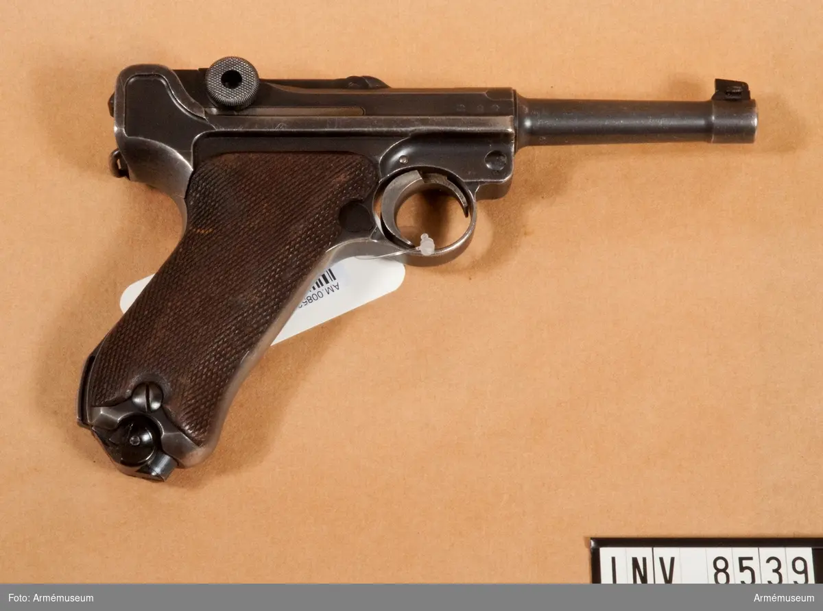 Halvautomatisk pistol, system Borchardt/Luger "Parabellum". Handgrepp av trä. Handgrepp har fäste för löskolv. Märkt S/42 1936 "tysk örn".

8-skotts magasin, märkt fxa p.08 37 (något skadat skick). Samma korn som gevär m/1896 Sverige.