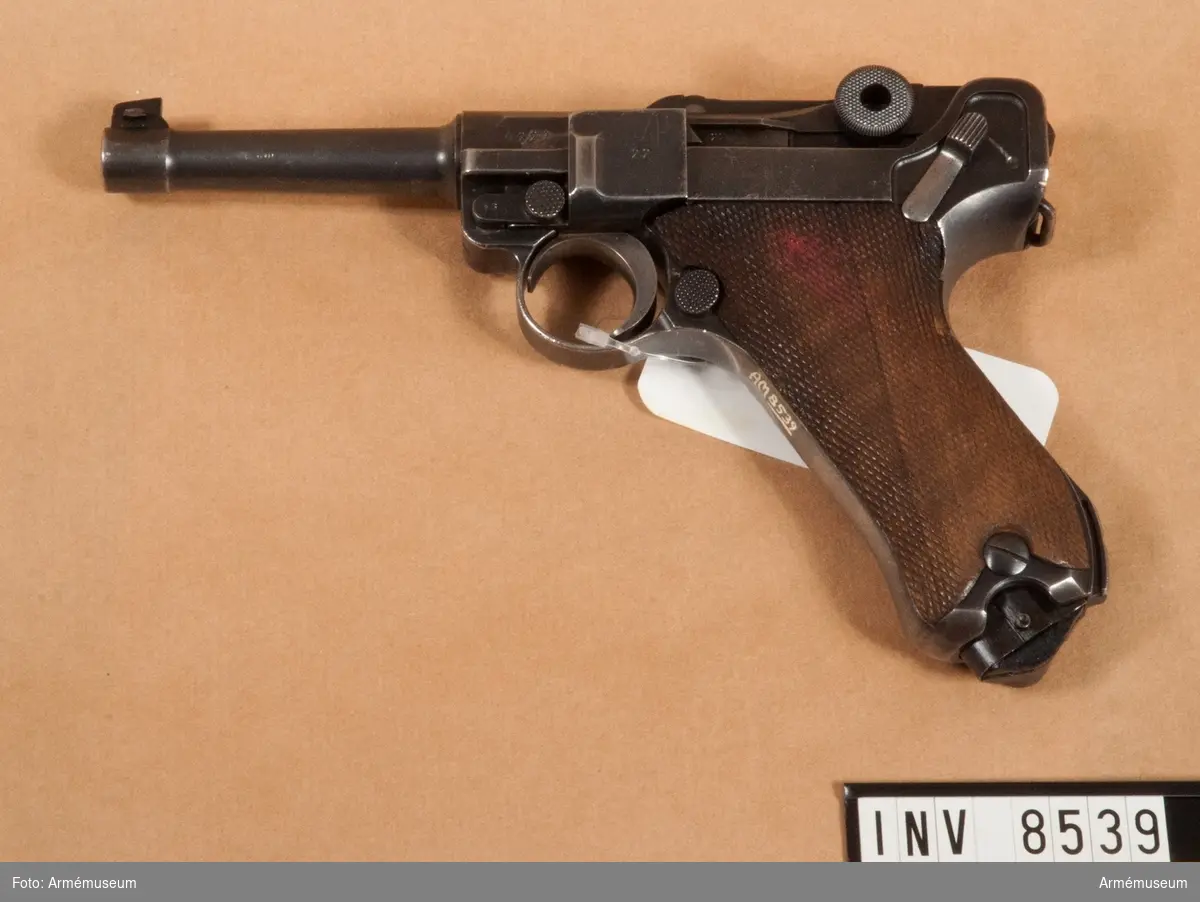 Halvautomatisk pistol, system Borchardt/Luger "Parabellum". Handgrepp av trä. Handgrepp har fäste för löskolv. Märkt S/42 1936 "tysk örn".

8-skotts magasin, märkt fxa p.08 37 (något skadat skick). Samma korn som gevär m/1896 Sverige.