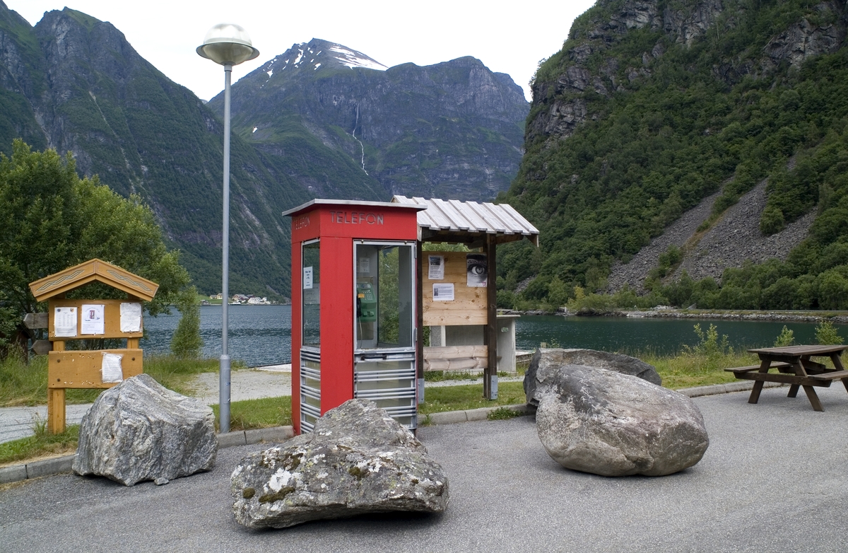 This is the story of how Norway’s most important conversation-space was designed by a young, freshly graduated man from Bergen.

“Norwegian architects are hereby invited…”
In the autumn of 1932, Oslo Telefonanlegginitiated an architectural competition. Finally, Oslo would get its own telephone booth. The city had had so called “talking-stations” from 1885, which in turn were overtaken by automatic telephones 
 only available at selected Narvesen kiosks. The state 
was of the opinion that now was the time to offer the public a better service; public telephone booths open 24/7, like the ones they already had in Sweden and England. But what would they look like, these new telephone booths? What considerations would it
 be necessary to take when designing it? The telegraph board developed a detailed list of demands and restraints: “The booth is intended to be placed outside on the streets and squares and need to be designed so that snow and ice does not hinder the opening and closing of the doors,” they wrote. “To prevent vandalism, theft, uncleanliness etc. inside the booth, it needs to be designed so that from all angles one may see what is going on in there.” Additionally, it would need to withstand storms and bad weather, and “preferably also being whipped by rain mixed with seawater” 

This was not all: The appearance would have to be «pleasing». The booth also needed to be movable, so that it could be taken in to be serviced at Telegrafverket’s main workshops. The reqired material was iron, and the surface was to be spray painted  preferably using car-body paint. There was a requirement for “a writing shelf, a pack shelf, and a suitable place for the telephone catalogue.” Also, there would need to be an illuminated TELEFON  sign, easily visible from all four angles. The total cost for each booth should not exceed 1000 kroner. The first prize for coming up with such a product was 800 kroner.

“Norwegianarchitects are hereby invited to partake in a competition for the design of a telephone booth…”  

The man with the solution
«At some point in 1932, Georg Fredrik sat at a party in Bergen. Maybe he felt a bit lost and forgotten as he often had throughout his life. He retreated to a quiet corner, took out a pencil and strted doodling on a matchbox.  According to my mother, this was how the telephone booth came into being.” In the book “Norges lille røde  historien om telefonkiosken,” Lars Fasting describes his father, the man who is far less known than the iconic architctural structure he left behind. Georg Fredrik Fasting was from Bergen, born into a family of working people and smallholders. One unusual facet of Georg Fredrik was that he was born without ears. His mother made sure he learnt to speak, read and write, 
ut Lars Fasting indicates that his father would seek refuge in drawing when the social challenges became too much to bear. And in the end drawing became his profession. In 1924 he secured a guarantor for a student loan, and started studying to become an a
rchitect at the NTH. Throughout the 1930s he entered several architectural competitions, with drafts produced, according to his son, “after work and in the late hours of the night.”

His efforts were not wasted. Out of 93 entries, with names such as “Flirt”, “Brrr”, “Ring” and “Amor”, the jury selected Fasting’s submission, “RIKS” as the new telephone booth: “The draft shows a strikingly simple solution to the task, technically as well as aesthetically well worked out.”

Taut and provident
Simple and aesthetc are the keywords here. Fasting had designed a booth pointing towards the future, and to modernism. Just how modern it was can be seen by comparing RIKS to the British telephone booth, also designed in the interwar-era. While the British version with it classicistic style is looking back to the heyday of the empire, Fasting’s booth is progressive and functionalistic. Like most Norwegian architects, Fasting broke with the classicistic style of architecture after the Stockholm-exhibition in 1930. “After it, almost all buildings erected in Norway until the German invasion in 1940, were in the functionalistic architectural style,” writes senior curator of architecture at the Norwegian National Museum, Ulf Grønvold, in the book, “Den lille røde”.“TheNorwegian booth is a piece of functionalistic architecture, an asymmetric composition with its roof slab overhanging the word TELEFON, in bold sans seraph lettering,”concludes Ulf Grønvold.

Fashionably red
And it was red. Fasting chose a colour which was part of the modern palette. “A bright red colour, but not as shiny as a signal red, the character of the colour places it among the fashionable colours within functionalism,” states paintings conservator and researcher in NIKU (Norwegian Institute for Cultural Heitage Research), Jon Brænne. In his opinion, Fasting went for visibility without making the booth stand out too much from its surroundings. The original colour was in use up to around 1950, when it changed to signal red. Towards the end of the 1970s the clour was again adjusted towards today’s orangey red.

The design, however, has not changed. RIKS is eighty years and still looks remarkably good. That’s what makes Fasting’s telephone booth a classic  even before it was added to DOCOMOMO’s list over moden icons of design. For Telenor, the telephone booth has served as a pathway into the hearts of the public. For many, Telenor (Televerket) was synonymous with exactly this telephone booth, because this was where one would go to place a call. Having a home
phone was not common until the 1980s. As such the red box became part of the Norwegian everyday and consciousness. The symbol- and publicity value of this is hard to evaluate, but in 2007 it was time to give honour where honour was due, Telenor, in consul
tation with the Directorate for Cultural Heritage, decided to preserve 100 telephone booths for all eternity.

And what about Georg Fredrik Fasting? What happened to him? At the age of 56 an entry in his diary states: «I CAN HEAR». As the first person in th world he had undergone an operation where he had ear canals constructed and eardrums fitted. For the rest of his life, the man behind Norway’s own telephone booth could answer the telephone himself.

Source: Norges lille røde historien om telefonkiosken (2007), issued by The Norwegian Telecom Museum and Telenor Cultural Heritage.