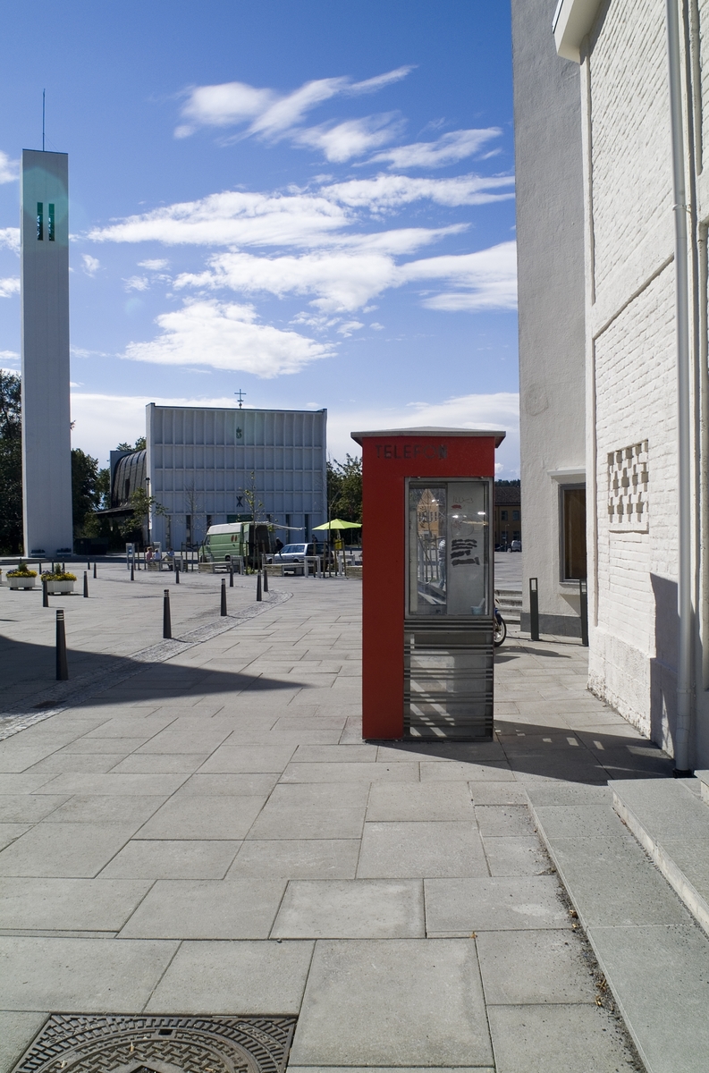 This is the story of how Norway’s most important conversation-space was designed by a young, freshly graduated man from Bergen.

“Norwegian architects are hereby invited…”
In the autumn of 1932, Oslo Telefonanlegginitiated an architectural competition. Finally, Oslo would get its own telephone booth. The city had had so called “talking-stations” from 1885, which in turn were overtaken by automatic telephones 
 only available at selected Narvesen kiosks. The state 
was of the opinion that now was the time to offer the public a better service; public telephone booths open 24/7, like the ones they already had in Sweden and England. But what would they look like, these new telephone booths? What considerations would it
 be necessary to take when designing it? The telegraph board developed a detailed list of demands and restraints: “The booth is intended to be placed outside on the streets and squares and need to be designed so that snow and ice does not hinder the opening and closing of the doors,” they wrote. “To prevent vandalism, theft, uncleanliness etc. inside the booth, it needs to be designed so that from all angles one may see what is going on in there.” Additionally, it would need to withstand storms and bad weather, and “preferably also being whipped by rain mixed with seawater” 

This was not all: The appearance would have to be «pleasing». The booth also needed to be movable, so that it could be taken in to be serviced at Telegrafverket’s main workshops. The reqired material was iron, and the surface was to be spray painted  preferably using car-body paint. There was a requirement for “a writing shelf, a pack shelf, and a suitable place for the telephone catalogue.” Also, there would need to be an illuminated TELEFON  sign, easily visible from all four angles. The total cost for each booth should not exceed 1000 kroner. The first prize for coming up with such a product was 800 kroner.

“Norwegianarchitects are hereby invited to partake in a competition for the design of a telephone booth…”  

The man with the solution
«At some point in 1932, Georg Fredrik sat at a party in Bergen. Maybe he felt a bit lost and forgotten as he often had throughout his life. He retreated to a quiet corner, took out a pencil and strted doodling on a matchbox.  According to my mother, this was how the telephone booth came into being.” In the book “Norges lille røde  historien om telefonkiosken,” Lars Fasting describes his father, the man who is far less known than the iconic architctural structure he left behind. Georg Fredrik Fasting was from Bergen, born into a family of working people and smallholders. One unusual facet of Georg Fredrik was that he was born without ears. His mother made sure he learnt to speak, read and write, 
ut Lars Fasting indicates that his father would seek refuge in drawing when the social challenges became too much to bear. And in the end drawing became his profession. In 1924 he secured a guarantor for a student loan, and started studying to become an a
rchitect at the NTH. Throughout the 1930s he entered several architectural competitions, with drafts produced, according to his son, “after work and in the late hours of the night.”

His efforts were not wasted. Out of 93 entries, with names such as “Flirt”, “Brrr”, “Ring” and “Amor”, the jury selected Fasting’s submission, “RIKS” as the new telephone booth: “The draft shows a strikingly simple solution to the task, technically as well as aesthetically well worked out.”

Taut and provident
Simple and aesthetc are the keywords here. Fasting had designed a booth pointing towards the future, and to modernism. Just how modern it was can be seen by comparing RIKS to the British telephone booth, also designed in the interwar-era. While the British version with it classicistic style is looking back to the heyday of the empire, Fasting’s booth is progressive and functionalistic. Like most Norwegian architects, Fasting broke with the classicistic style of architecture after the Stockholm-exhibition in 1930. “After it, almost all buildings erected in Norway until the German invasion in 1940, were in the functionalistic architectural style,” writes senior curator of architecture at the Norwegian National Museum, Ulf Grønvold, in the book, “Den lille røde”.“TheNorwegian booth is a piece of functionalistic architecture, an asymmetric composition with its roof slab overhanging the word TELEFON, in bold sans seraph lettering,”concludes Ulf Grønvold.

Fashionably red
And it was red. Fasting chose a colour which was part of the modern palette. “A bright red colour, but not as shiny as a signal red, the character of the colour places it among the fashionable colours within functionalism,” states paintings conservator and researcher in NIKU (Norwegian Institute for Cultural Heitage Research), Jon Brænne. In his opinion, Fasting went for visibility without making the booth stand out too much from its surroundings. The original colour was in use up to around 1950, when it changed to signal red. Towards the end of the 1970s the clour was again adjusted towards today’s orangey red.

The design, however, has not changed. RIKS is eighty years and still looks remarkably good. That’s what makes Fasting’s telephone booth a classic  even before it was added to DOCOMOMO’s list over moden icons of design. For Telenor, the telephone booth has served as a pathway into the hearts of the public. For many, Telenor (Televerket) was synonymous with exactly this telephone booth, because this was where one would go to place a call. Having a home
phone was not common until the 1980s. As such the red box became part of the Norwegian everyday and consciousness. The symbol- and publicity value of this is hard to evaluate, but in 2007 it was time to give honour where honour was due, Telenor, in consul
tation with the Directorate for Cultural Heritage, decided to preserve 100 telephone booths for all eternity.

And what about Georg Fredrik Fasting? What happened to him? At the age of 56 an entry in his diary states: «I CAN HEAR». As the first person in th world he had undergone an operation where he had ear canals constructed and eardrums fitted. For the rest of his life, the man behind Norway’s own telephone booth could answer the telephone himself.

Source: Norges lille røde historien om telefonkiosken (2007), issued by The Norwegian Telecom Museum and Telenor Cultural Heritage.