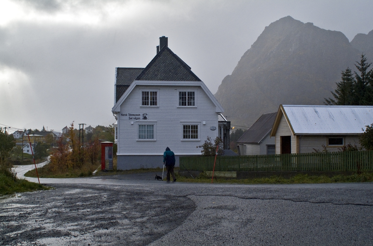 This is the story of how Norway’s most important conversation-space was designed by a young, freshly graduated man from Bergen.

“Norwegian architects are hereby invited…”
In the autumn of 1932, Oslo Telefonanlegginitiated an architectural competition. Finally, Oslo would get its own telephone booth. The city had had so called “talking-stations” from 1885, which in turn were overtaken by automatic telephones 
 only available at selected Narvesen kiosks. The state 
was of the opinion that now was the time to offer the public a better service; public telephone booths open 24/7, like the ones they already had in Sweden and England. But what would they look like, these new telephone booths? What considerations would it
 be necessary to take when designing it? The telegraph board developed a detailed list of demands and restraints: “The booth is intended to be placed outside on the streets and squares and need to be designed so that snow and ice does not hinder the opening and closing of the doors,” they wrote. “To prevent vandalism, theft, uncleanliness etc. inside the booth, it needs to be designed so that from all angles one may see what is going on in there.” Additionally, it would need to withstand storms and bad weather, and “preferably also being whipped by rain mixed with seawater” 

This was not all: The appearance would have to be «pleasing». The booth also needed to be movable, so that it could be taken in to be serviced at Telegrafverket’s main workshops. The reqired material was iron, and the surface was to be spray painted  preferably using car-body paint. There was a requirement for “a writing shelf, a pack shelf, and a suitable place for the telephone catalogue.” Also, there would need to be an illuminated TELEFON  sign, easily visible from all four angles. The total cost for each booth should not exceed 1000 kroner. The first prize for coming up with such a product was 800 kroner.

“Norwegianarchitects are hereby invited to partake in a competition for the design of a telephone booth…”  

The man with the solution
«At some point in 1932, Georg Fredrik sat at a party in Bergen. Maybe he felt a bit lost and forgotten as he often had throughout his life. He retreated to a quiet corner, took out a pencil and strted doodling on a matchbox.  According to my mother, this was how the telephone booth came into being.” In the book “Norges lille røde  historien om telefonkiosken,” Lars Fasting describes his father, the man who is far less known than the iconic architctural structure he left behind. Georg Fredrik Fasting was from Bergen, born into a family of working people and smallholders. One unusual facet of Georg Fredrik was that he was born without ears. His mother made sure he learnt to speak, read and write, 
ut Lars Fasting indicates that his father would seek refuge in drawing when the social challenges became too much to bear. And in the end drawing became his profession. In 1924 he secured a guarantor for a student loan, and started studying to become an a
rchitect at the NTH. Throughout the 1930s he entered several architectural competitions, with drafts produced, according to his son, “after work and in the late hours of the night.”

His efforts were not wasted. Out of 93 entries, with names such as “Flirt”, “Brrr”, “Ring” and “Amor”, the jury selected Fasting’s submission, “RIKS” as the new telephone booth: “The draft shows a strikingly simple solution to the task, technically as well as aesthetically well worked out.”

Taut and provident
Simple and aesthetc are the keywords here. Fasting had designed a booth pointing towards the future, and to modernism. Just how modern it was can be seen by comparing RIKS to the British telephone booth, also designed in the interwar-era. While the British version with it classicistic style is looking back to the heyday of the empire, Fasting’s booth is progressive and functionalistic. Like most Norwegian architects, Fasting broke with the classicistic style of architecture after the Stockholm-exhibition in 1930. “After it, almost all buildings erected in Norway until the German invasion in 1940, were in the functionalistic architectural style,” writes senior curator of architecture at the Norwegian National Museum, Ulf Grønvold, in the book, “Den lille røde”.“TheNorwegian booth is a piece of functionalistic architecture, an asymmetric composition with its roof slab overhanging the word TELEFON, in bold sans seraph lettering,”concludes Ulf Grønvold.

Fashionably red
And it was red. Fasting chose a colour which was part of the modern palette. “A bright red colour, but not as shiny as a signal red, the character of the colour places it among the fashionable colours within functionalism,” states paintings conservator and researcher in NIKU (Norwegian Institute for Cultural Heitage Research), Jon Brænne. In his opinion, Fasting went for visibility without making the booth stand out too much from its surroundings. The original colour was in use up to around 1950, when it changed to signal red. Towards the end of the 1970s the clour was again adjusted towards today’s orangey red.

The design, however, has not changed. RIKS is eighty years and still looks remarkably good. That’s what makes Fasting’s telephone booth a classic  even before it was added to DOCOMOMO’s list over moden icons of design. For Telenor, the telephone booth has served as a pathway into the hearts of the public. For many, Telenor (Televerket) was synonymous with exactly this telephone booth, because this was where one would go to place a call. Having a home
phone was not common until the 1980s. As such the red box became part of the Norwegian everyday and consciousness. The symbol- and publicity value of this is hard to evaluate, but in 2007 it was time to give honour where honour was due, Telenor, in consul
tation with the Directorate for Cultural Heritage, decided to preserve 100 telephone booths for all eternity.

And what about Georg Fredrik Fasting? What happened to him? At the age of 56 an entry in his diary states: «I CAN HEAR». As the first person in th world he had undergone an operation where he had ear canals constructed and eardrums fitted. For the rest of his life, the man behind Norway’s own telephone booth could answer the telephone himself.

Source: Norges lille røde historien om telefonkiosken (2007), issued by The Norwegian Telecom Museum and Telenor Cultural Heritage.