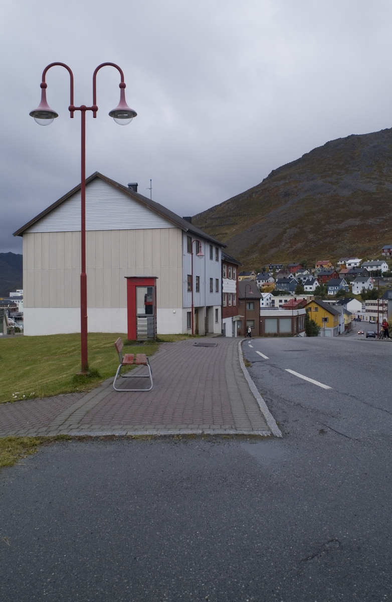 This is the story of how Norway’s most important conversation-space was designed by a young, freshly graduated man from Bergen.

“Norwegian architects are hereby invited…”
In the autumn of 1932, Oslo Telefonanlegginitiated an architectural competition. Finally, Oslo would get its own telephone booth. The city had had so called “talking-stations” from 1885, which in turn were overtaken by automatic telephones 
 only available at selected Narvesen kiosks. The state 
was of the opinion that now was the time to offer the public a better service; public telephone booths open 24/7, like the ones they already had in Sweden and England. But what would they look like, these new telephone booths? What considerations would it
 be necessary to take when designing it? The telegraph board developed a detailed list of demands and restraints: “The booth is intended to be placed outside on the streets and squares and need to be designed so that snow and ice does not hinder the opening and closing of the doors,” they wrote. “To prevent vandalism, theft, uncleanliness etc. inside the booth, it needs to be designed so that from all angles one may see what is going on in there.” Additionally, it would need to withstand storms and bad weather, and “preferably also being whipped by rain mixed with seawater” 

This was not all: The appearance would have to be «pleasing». The booth also needed to be movable, so that it could be taken in to be serviced at Telegrafverket’s main workshops. The reqired material was iron, and the surface was to be spray painted  preferably using car-body paint. There was a requirement for “a writing shelf, a pack shelf, and a suitable place for the telephone catalogue.” Also, there would need to be an illuminated TELEFON  sign, easily visible from all four angles. The total cost for each booth should not exceed 1000 kroner. The first prize for coming up with such a product was 800 kroner.

“Norwegianarchitects are hereby invited to partake in a competition for the design of a telephone booth…”  

The man with the solution
«At some point in 1932, Georg Fredrik sat at a party in Bergen. Maybe he felt a bit lost and forgotten as he often had throughout his life. He retreated to a quiet corner, took out a pencil and strted doodling on a matchbox.  According to my mother, this was how the telephone booth came into being.” In the book “Norges lille røde  historien om telefonkiosken,” Lars Fasting describes his father, the man who is far less known than the iconic architctural structure he left behind. Georg Fredrik Fasting was from Bergen, born into a family of working people and smallholders. One unusual facet of Georg Fredrik was that he was born without ears. His mother made sure he learnt to speak, read and write, 
ut Lars Fasting indicates that his father would seek refuge in drawing when the social challenges became too much to bear. And in the end drawing became his profession. In 1924 he secured a guarantor for a student loan, and started studying to become an a
rchitect at the NTH. Throughout the 1930s he entered several architectural competitions, with drafts produced, according to his son, “after work and in the late hours of the night.”

His efforts were not wasted. Out of 93 entries, with names such as “Flirt”, “Brrr”, “Ring” and “Amor”, the jury selected Fasting’s submission, “RIKS” as the new telephone booth: “The draft shows a strikingly simple solution to the task, technically as well as aesthetically well worked out.”

Taut and provident
Simple and aesthetc are the keywords here. Fasting had designed a booth pointing towards the future, and to modernism. Just how modern it was can be seen by comparing RIKS to the British telephone booth, also designed in the interwar-era. While the British version with it classicistic style is looking back to the heyday of the empire, Fasting’s booth is progressive and functionalistic. Like most Norwegian architects, Fasting broke with the classicistic style of architecture after the Stockholm-exhibition in 1930. “After it, almost all buildings erected in Norway until the German invasion in 1940, were in the functionalistic architectural style,” writes senior curator of architecture at the Norwegian National Museum, Ulf Grønvold, in the book, “Den lille røde”.“TheNorwegian booth is a piece of functionalistic architecture, an asymmetric composition with its roof slab overhanging the word TELEFON, in bold sans seraph lettering,”concludes Ulf Grønvold.

Fashionably red
And it was red. Fasting chose a colour which was part of the modern palette. “A bright red colour, but not as shiny as a signal red, the character of the colour places it among the fashionable colours within functionalism,” states paintings conservator and researcher in NIKU (Norwegian Institute for Cultural Heitage Research), Jon Brænne. In his opinion, Fasting went for visibility without making the booth stand out too much from its surroundings. The original colour was in use up to around 1950, when it changed to signal red. Towards the end of the 1970s the clour was again adjusted towards today’s orangey red.

The design, however, has not changed. RIKS is eighty years and still looks remarkably good. That’s what makes Fasting’s telephone booth a classic  even before it was added to DOCOMOMO’s list over moden icons of design. For Telenor, the telephone booth has served as a pathway into the hearts of the public. For many, Telenor (Televerket) was synonymous with exactly this telephone booth, because this was where one would go to place a call. Having a home
phone was not common until the 1980s. As such the red box became part of the Norwegian everyday and consciousness. The symbol- and publicity value of this is hard to evaluate, but in 2007 it was time to give honour where honour was due, Telenor, in consul
tation with the Directorate for Cultural Heritage, decided to preserve 100 telephone booths for all eternity.

And what about Georg Fredrik Fasting? What happened to him? At the age of 56 an entry in his diary states: «I CAN HEAR». As the first person in th world he had undergone an operation where he had ear canals constructed and eardrums fitted. For the rest of his life, the man behind Norway’s own telephone booth could answer the telephone himself.

Source: Norges lille røde historien om telefonkiosken (2007), issued by The Norwegian Telecom Museum and Telenor Cultural Heritage.