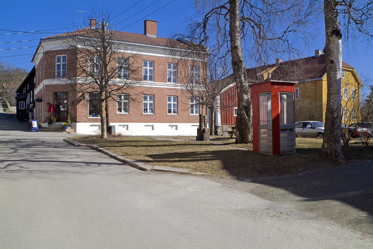 This is the story of how Norway’s most important conversation-space was designed by a young, freshly graduated man from Bergen.

“Norwegian architects are hereby invited…”
In the autumn of 1932, Oslo Telefonanlegginitiated an architectural competition. Finally, Oslo would get its own telephone booth. The city had had so called “talking-stations” from 1885, which in turn were overtaken by automatic telephones 
 only available at selected Narvesen kiosks. The state 
was of the opinion that now was the time to offer the public a better service; public telephone booths open 24/7, like the ones they already had in Sweden and England. But what would they look like, these new telephone booths? What considerations would it
 be necessary to take when designing it? The telegraph board developed a detailed list of demands and restraints: “The booth is intended to be placed outside on the streets and squares and need to be designed so that snow and ice does not hinder the opening and closing of the doors,” they wrote. “To prevent vandalism, theft, uncleanliness etc. inside the booth, it needs to be designed so that from all angles one may see what is going on in there.” Additionally, it would need to withstand storms and bad weather, and “preferably also being whipped by rain mixed with seawater” 

This was not all: The appearance would have to be «pleasing». The booth also needed to be movable, so that it could be taken in to be serviced at Telegrafverket’s main workshops. The reqired material was iron, and the surface was to be spray painted  preferably using car-body paint. There was a requirement for “a writing shelf, a pack shelf, and a suitable place for the telephone catalogue.” Also, there would need to be an illuminated TELEFON  sign, easily visible from all four angles. The total cost for each booth should not exceed 1000 kroner. The first prize for coming up with such a product was 800 kroner.

“Norwegianarchitects are hereby invited to partake in a competition for the design of a telephone booth…”  

The man with the solution
«At some point in 1932, Georg Fredrik sat at a party in Bergen. Maybe he felt a bit lost and forgotten as he often had throughout his life. He retreated to a quiet corner, took out a pencil and strted doodling on a matchbox.  According to my mother, this was how the telephone booth came into being.” In the book “Norges lille røde  historien om telefonkiosken,” Lars Fasting describes his father, the man who is far less known than the iconic architctural structure he left behind. Georg Fredrik Fasting was from Bergen, born into a family of working people and smallholders. One unusual facet of Georg Fredrik was that he was born without ears. His mother made sure he learnt to speak, read and write, 
ut Lars Fasting indicates that his father would seek refuge in drawing when the social challenges became too much to bear. And in the end drawing became his profession. In 1924 he secured a guarantor for a student loan, and started studying to become an a
rchitect at the NTH. Throughout the 1930s he entered several architectural competitions, with drafts produced, according to his son, “after work and in the late hours of the night.”

His efforts were not wasted. Out of 93 entries, with names such as “Flirt”, “Brrr”, “Ring” and “Amor”, the jury selected Fasting’s submission, “RIKS” as the new telephone booth: “The draft shows a strikingly simple solution to the task, technically as well as aesthetically well worked out.”

Taut and provident
Simple and aesthetc are the keywords here. Fasting had designed a booth pointing towards the future, and to modernism. Just how modern it was can be seen by comparing RIKS to the British telephone booth, also designed in the interwar-era. While the British version with it classicistic style is looking back to the heyday of the empire, Fasting’s booth is progressive and functionalistic. Like most Norwegian architects, Fasting broke with the classicistic style of architecture after the Stockholm-exhibition in 1930. “After it, almost all buildings erected in Norway until the German invasion in 1940, were in the functionalistic architectural style,” writes senior curator of architecture at the Norwegian National Museum, Ulf Grønvold, in the book, “Den lille røde”.“TheNorwegian booth is a piece of functionalistic architecture, an asymmetric composition with its roof slab overhanging the word TELEFON, in bold sans seraph lettering,”concludes Ulf Grønvold.

Fashionably red
And it was red. Fasting chose a colour which was part of the modern palette. “A bright red colour, but not as shiny as a signal red, the character of the colour places it among the fashionable colours within functionalism,” states paintings conservator and researcher in NIKU (Norwegian Institute for Cultural Heitage Research), Jon Brænne. In his opinion, Fasting went for visibility without making the booth stand out too much from its surroundings. The original colour was in use up to around 1950, when it changed to signal red. Towards the end of the 1970s the clour was again adjusted towards today’s orangey red.

The design, however, has not changed. RIKS is eighty years and still looks remarkably good. That’s what makes Fasting’s telephone booth a classic  even before it was added to DOCOMOMO’s list over moden icons of design. For Telenor, the telephone booth has served as a pathway into the hearts of the public. For many, Telenor (Televerket) was synonymous with exactly this telephone booth, because this was where one would go to place a call. Having a home
phone was not common until the 1980s. As such the red box became part of the Norwegian everyday and consciousness. The symbol- and publicity value of this is hard to evaluate, but in 2007 it was time to give honour where honour was due, Telenor, in consul
tation with the Directorate for Cultural Heritage, decided to preserve 100 telephone booths for all eternity.

And what about Georg Fredrik Fasting? What happened to him? At the age of 56 an entry in his diary states: «I CAN HEAR». As the first person in th world he had undergone an operation where he had ear canals constructed and eardrums fitted. For the rest of his life, the man behind Norway’s own telephone booth could answer the telephone himself.

Source: Norges lille røde historien om telefonkiosken (2007), issued by The Norwegian Telecom Museum and Telenor Cultural Heritage.