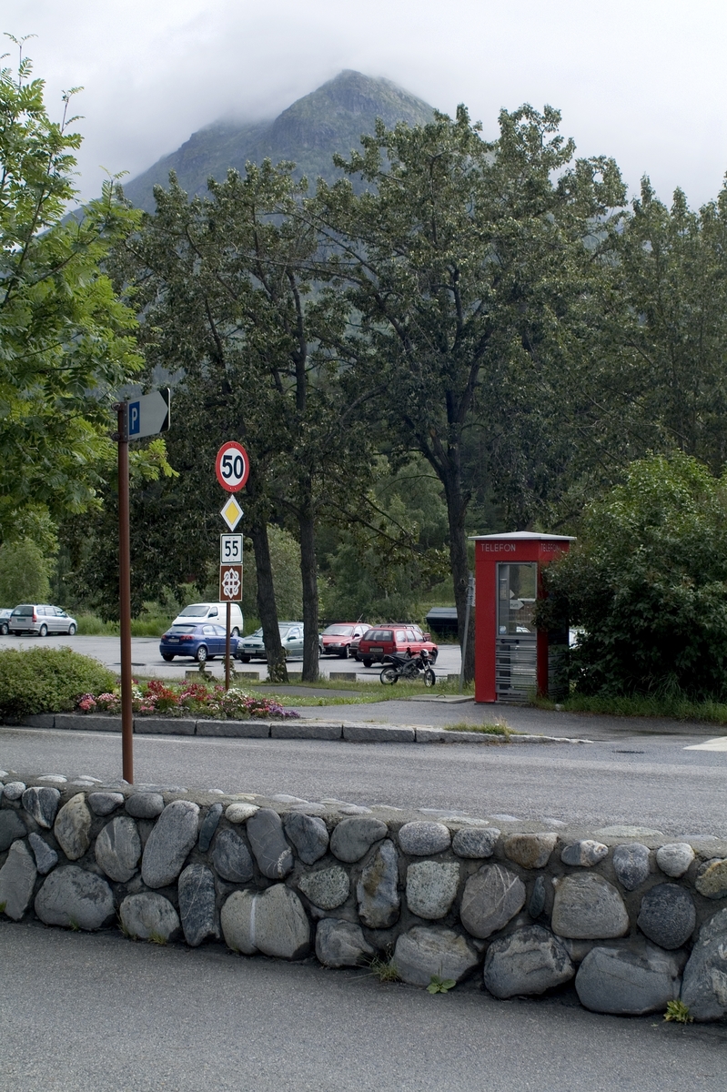 This is the story of how Norway’s most important conversation-space was designed by a young, freshly graduated man from Bergen.

“Norwegian architects are hereby invited…”
In the autumn of 1932, Oslo Telefonanlegginitiated an architectural competition. Finally, Oslo would get its own telephone booth. The city had had so called “talking-stations” from 1885, which in turn were overtaken by automatic telephones 
 only available at selected Narvesen kiosks. The state 
was of the opinion that now was the time to offer the public a better service; public telephone booths open 24/7, like the ones they already had in Sweden and England. But what would they look like, these new telephone booths? What considerations would it
 be necessary to take when designing it? The telegraph board developed a detailed list of demands and restraints: “The booth is intended to be placed outside on the streets and squares and need to be designed so that snow and ice does not hinder the opening and closing of the doors,” they wrote. “To prevent vandalism, theft, uncleanliness etc. inside the booth, it needs to be designed so that from all angles one may see what is going on in there.” Additionally, it would need to withstand storms and bad weather, and “preferably also being whipped by rain mixed with seawater” 

This was not all: The appearance would have to be «pleasing». The booth also needed to be movable, so that it could be taken in to be serviced at Telegrafverket’s main workshops. The reqired material was iron, and the surface was to be spray painted  preferably using car-body paint. There was a requirement for “a writing shelf, a pack shelf, and a suitable place for the telephone catalogue.” Also, there would need to be an illuminated TELEFON  sign, easily visible from all four angles. The total cost for each booth should not exceed 1000 kroner. The first prize for coming up with such a product was 800 kroner.

“Norwegianarchitects are hereby invited to partake in a competition for the design of a telephone booth…”  

The man with the solution
«At some point in 1932, Georg Fredrik sat at a party in Bergen. Maybe he felt a bit lost and forgotten as he often had throughout his life. He retreated to a quiet corner, took out a pencil and strted doodling on a matchbox.  According to my mother, this was how the telephone booth came into being.” In the book “Norges lille røde  historien om telefonkiosken,” Lars Fasting describes his father, the man who is far less known than the iconic architctural structure he left behind. Georg Fredrik Fasting was from Bergen, born into a family of working people and smallholders. One unusual facet of Georg Fredrik was that he was born without ears. His mother made sure he learnt to speak, read and write, 
ut Lars Fasting indicates that his father would seek refuge in drawing when the social challenges became too much to bear. And in the end drawing became his profession. In 1924 he secured a guarantor for a student loan, and started studying to become an a
rchitect at the NTH. Throughout the 1930s he entered several architectural competitions, with drafts produced, according to his son, “after work and in the late hours of the night.”

His efforts were not wasted. Out of 93 entries, with names such as “Flirt”, “Brrr”, “Ring” and “Amor”, the jury selected Fasting’s submission, “RIKS” as the new telephone booth: “The draft shows a strikingly simple solution to the task, technically as well as aesthetically well worked out.”

Taut and provident
Simple and aesthetc are the keywords here. Fasting had designed a booth pointing towards the future, and to modernism. Just how modern it was can be seen by comparing RIKS to the British telephone booth, also designed in the interwar-era. While the British version with it classicistic style is looking back to the heyday of the empire, Fasting’s booth is progressive and functionalistic. Like most Norwegian architects, Fasting broke with the classicistic style of architecture after the Stockholm-exhibition in 1930. “After it, almost all buildings erected in Norway until the German invasion in 1940, were in the functionalistic architectural style,” writes senior curator of architecture at the Norwegian National Museum, Ulf Grønvold, in the book, “Den lille røde”.“TheNorwegian booth is a piece of functionalistic architecture, an asymmetric composition with its roof slab overhanging the word TELEFON, in bold sans seraph lettering,”concludes Ulf Grønvold.

Fashionably red
And it was red. Fasting chose a colour which was part of the modern palette. “A bright red colour, but not as shiny as a signal red, the character of the colour places it among the fashionable colours within functionalism,” states paintings conservator and researcher in NIKU (Norwegian Institute for Cultural Heitage Research), Jon Brænne. In his opinion, Fasting went for visibility without making the booth stand out too much from its surroundings. The original colour was in use up to around 1950, when it changed to signal red. Towards the end of the 1970s the clour was again adjusted towards today’s orangey red.

The design, however, has not changed. RIKS is eighty years and still looks remarkably good. That’s what makes Fasting’s telephone booth a classic  even before it was added to DOCOMOMO’s list over moden icons of design. For Telenor, the telephone booth has served as a pathway into the hearts of the public. For many, Telenor (Televerket) was synonymous with exactly this telephone booth, because this was where one would go to place a call. Having a home
phone was not common until the 1980s. As such the red box became part of the Norwegian everyday and consciousness. The symbol- and publicity value of this is hard to evaluate, but in 2007 it was time to give honour where honour was due, Telenor, in consul
tation with the Directorate for Cultural Heritage, decided to preserve 100 telephone booths for all eternity.

And what about Georg Fredrik Fasting? What happened to him? At the age of 56 an entry in his diary states: «I CAN HEAR». As the first person in th world he had undergone an operation where he had ear canals constructed and eardrums fitted. For the rest of his life, the man behind Norway’s own telephone booth could answer the telephone himself.

Source: Norges lille røde historien om telefonkiosken (2007), issued by The Norwegian Telecom Museum and Telenor Cultural Heritage.