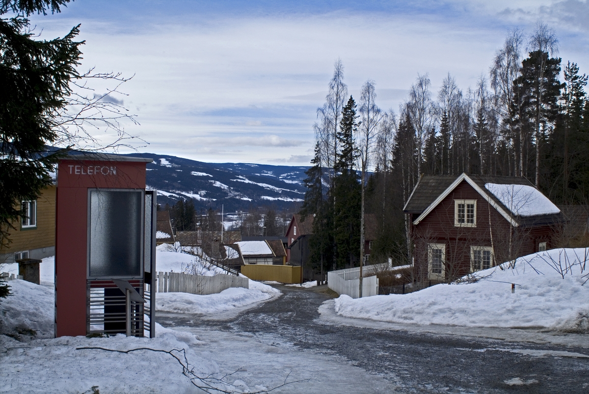 This is the story of how Norway’s most important conversation-space was designed by a young, freshly graduated man from Bergen.

“Norwegian architects are hereby invited…”
In the autumn of 1932, Oslo Telefonanlegginitiated an architectural competition. Finally, Oslo would get its own telephone booth. The city had had so called “talking-stations” from 1885, which in turn were overtaken by automatic telephones 
 only available at selected Narvesen kiosks. The state 
was of the opinion that now was the time to offer the public a better service; public telephone booths open 24/7, like the ones they already had in Sweden and England. But what would they look like, these new telephone booths? What considerations would it
 be necessary to take when designing it? The telegraph board developed a detailed list of demands and restraints: “The booth is intended to be placed outside on the streets and squares and need to be designed so that snow and ice does not hinder the opening and closing of the doors,” they wrote. “To prevent vandalism, theft, uncleanliness etc. inside the booth, it needs to be designed so that from all angles one may see what is going on in there.” Additionally, it would need to withstand storms and bad weather, and “preferably also being whipped by rain mixed with seawater” 

This was not all: The appearance would have to be «pleasing». The booth also needed to be movable, so that it could be taken in to be serviced at Telegrafverket’s main workshops. The reqired material was iron, and the surface was to be spray painted  preferably using car-body paint. There was a requirement for “a writing shelf, a pack shelf, and a suitable place for the telephone catalogue.” Also, there would need to be an illuminated TELEFON  sign, easily visible from all four angles. The total cost for each booth should not exceed 1000 kroner. The first prize for coming up with such a product was 800 kroner.

“Norwegianarchitects are hereby invited to partake in a competition for the design of a telephone booth…”  

The man with the solution
«At some point in 1932, Georg Fredrik sat at a party in Bergen. Maybe he felt a bit lost and forgotten as he often had throughout his life. He retreated to a quiet corner, took out a pencil and strted doodling on a matchbox.  According to my mother, this was how the telephone booth came into being.” In the book “Norges lille røde  historien om telefonkiosken,” Lars Fasting describes his father, the man who is far less known than the iconic architctural structure he left behind. Georg Fredrik Fasting was from Bergen, born into a family of working people and smallholders. One unusual facet of Georg Fredrik was that he was born without ears. His mother made sure he learnt to speak, read and write, 
ut Lars Fasting indicates that his father would seek refuge in drawing when the social challenges became too much to bear. And in the end drawing became his profession. In 1924 he secured a guarantor for a student loan, and started studying to become an a
rchitect at the NTH. Throughout the 1930s he entered several architectural competitions, with drafts produced, according to his son, “after work and in the late hours of the night.”

His efforts were not wasted. Out of 93 entries, with names such as “Flirt”, “Brrr”, “Ring” and “Amor”, the jury selected Fasting’s submission, “RIKS” as the new telephone booth: “The draft shows a strikingly simple solution to the task, technically as well as aesthetically well worked out.”

Taut and provident
Simple and aesthetc are the keywords here. Fasting had designed a booth pointing towards the future, and to modernism. Just how modern it was can be seen by comparing RIKS to the British telephone booth, also designed in the interwar-era. While the British version with it classicistic style is looking back to the heyday of the empire, Fasting’s booth is progressive and functionalistic. Like most Norwegian architects, Fasting broke with the classicistic style of architecture after the Stockholm-exhibition in 1930. “After it, almost all buildings erected in Norway until the German invasion in 1940, were in the functionalistic architectural style,” writes senior curator of architecture at the Norwegian National Museum, Ulf Grønvold, in the book, “Den lille røde”.“TheNorwegian booth is a piece of functionalistic architecture, an asymmetric composition with its roof slab overhanging the word TELEFON, in bold sans seraph lettering,”concludes Ulf Grønvold.

Fashionably red
And it was red. Fasting chose a colour which was part of the modern palette. “A bright red colour, but not as shiny as a signal red, the character of the colour places it among the fashionable colours within functionalism,” states paintings conservator and researcher in NIKU (Norwegian Institute for Cultural Heitage Research), Jon Brænne. In his opinion, Fasting went for visibility without making the booth stand out too much from its surroundings. The original colour was in use up to around 1950, when it changed to signal red. Towards the end of the 1970s the clour was again adjusted towards today’s orangey red.

The design, however, has not changed. RIKS is eighty years and still looks remarkably good. That’s what makes Fasting’s telephone booth a classic  even before it was added to DOCOMOMO’s list over moden icons of design. For Telenor, the telephone booth has served as a pathway into the hearts of the public. For many, Telenor (Televerket) was synonymous with exactly this telephone booth, because this was where one would go to place a call. Having a home
phone was not common until the 1980s. As such the red box became part of the Norwegian everyday and consciousness. The symbol- and publicity value of this is hard to evaluate, but in 2007 it was time to give honour where honour was due, Telenor, in consul
tation with the Directorate for Cultural Heritage, decided to preserve 100 telephone booths for all eternity.

And what about Georg Fredrik Fasting? What happened to him? At the age of 56 an entry in his diary states: «I CAN HEAR». As the first person in th world he had undergone an operation where he had ear canals constructed and eardrums fitted. For the rest of his life, the man behind Norway’s own telephone booth could answer the telephone himself.

Source: Norges lille røde historien om telefonkiosken (2007), issued by The Norwegian Telecom Museum and Telenor Cultural Heritage.