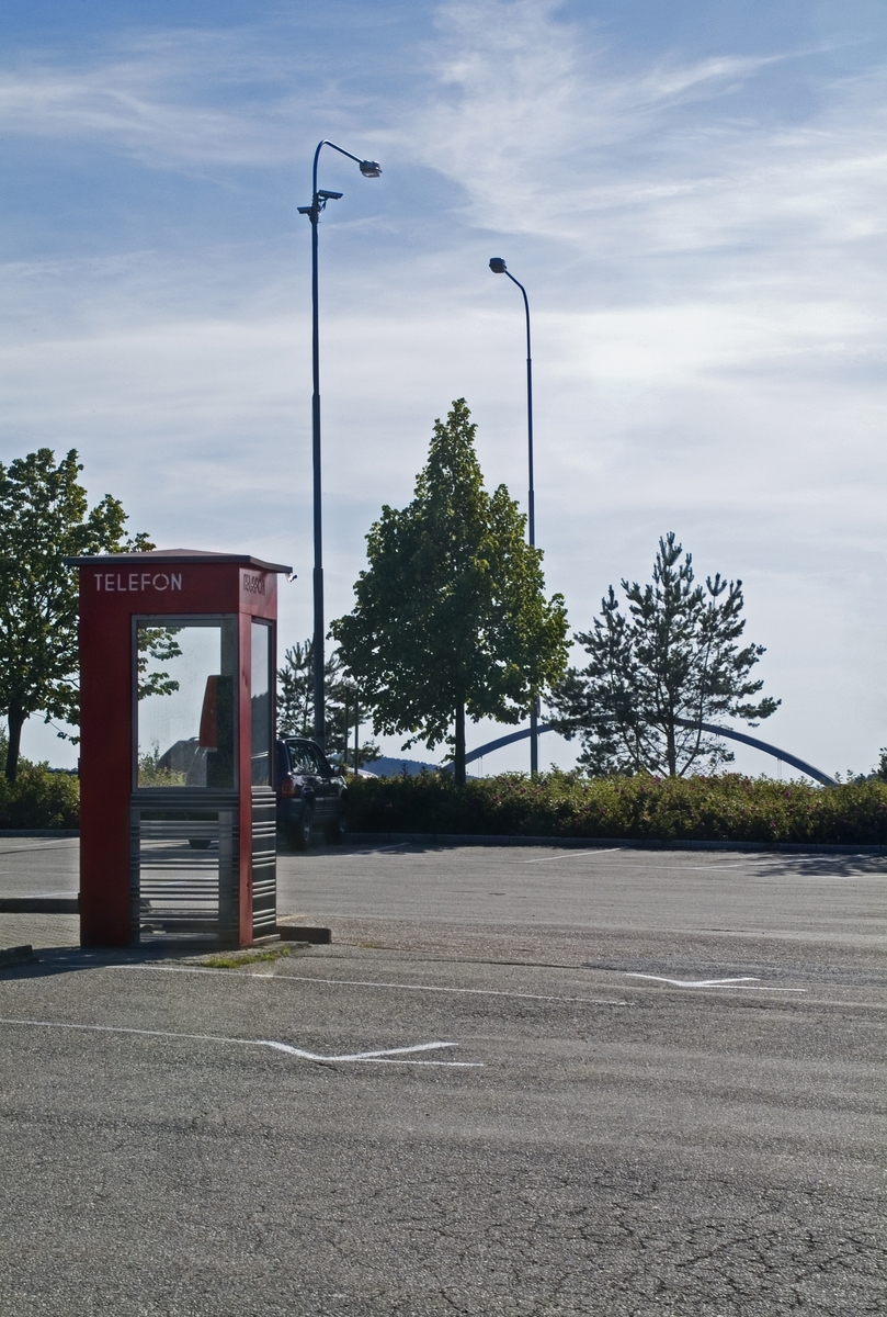 This is the story of how Norway’s most important conversation-space was designed by a young, freshly graduated man from Bergen.

“Norwegian architects are hereby invited…”
In the autumn of 1932, Oslo Telefonanlegginitiated an architectural competition. Finally, Oslo would get its own telephone booth. The city had had so called “talking-stations” from 1885, which in turn were overtaken by automatic telephones 
 only available at selected Narvesen kiosks. The state 
was of the opinion that now was the time to offer the public a better service; public telephone booths open 24/7, like the ones they already had in Sweden and England. But what would they look like, these new telephone booths? What considerations would it
 be necessary to take when designing it? The telegraph board developed a detailed list of demands and restraints: “The booth is intended to be placed outside on the streets and squares and need to be designed so that snow and ice does not hinder the opening and closing of the doors,” they wrote. “To prevent vandalism, theft, uncleanliness etc. inside the booth, it needs to be designed so that from all angles one may see what is going on in there.” Additionally, it would need to withstand storms and bad weather, and “preferably also being whipped by rain mixed with seawater” 

This was not all: The appearance would have to be «pleasing». The booth also needed to be movable, so that it could be taken in to be serviced at Telegrafverket’s main workshops. The reqired material was iron, and the surface was to be spray painted  preferably using car-body paint. There was a requirement for “a writing shelf, a pack shelf, and a suitable place for the telephone catalogue.” Also, there would need to be an illuminated TELEFON  sign, easily visible from all four angles. The total cost for each booth should not exceed 1000 kroner. The first prize for coming up with such a product was 800 kroner.

“Norwegianarchitects are hereby invited to partake in a competition for the design of a telephone booth…”  

The man with the solution
«At some point in 1932, Georg Fredrik sat at a party in Bergen. Maybe he felt a bit lost and forgotten as he often had throughout his life. He retreated to a quiet corner, took out a pencil and strted doodling on a matchbox.  According to my mother, this was how the telephone booth came into being.” In the book “Norges lille røde  historien om telefonkiosken,” Lars Fasting describes his father, the man who is far less known than the iconic architctural structure he left behind. Georg Fredrik Fasting was from Bergen, born into a family of working people and smallholders. One unusual facet of Georg Fredrik was that he was born without ears. His mother made sure he learnt to speak, read and write, 
ut Lars Fasting indicates that his father would seek refuge in drawing when the social challenges became too much to bear. And in the end drawing became his profession. In 1924 he secured a guarantor for a student loan, and started studying to become an a
rchitect at the NTH. Throughout the 1930s he entered several architectural competitions, with drafts produced, according to his son, “after work and in the late hours of the night.”

His efforts were not wasted. Out of 93 entries, with names such as “Flirt”, “Brrr”, “Ring” and “Amor”, the jury selected Fasting’s submission, “RIKS” as the new telephone booth: “The draft shows a strikingly simple solution to the task, technically as well as aesthetically well worked out.”

Taut and provident
Simple and aesthetc are the keywords here. Fasting had designed a booth pointing towards the future, and to modernism. Just how modern it was can be seen by comparing RIKS to the British telephone booth, also designed in the interwar-era. While the British version with it classicistic style is looking back to the heyday of the empire, Fasting’s booth is progressive and functionalistic. Like most Norwegian architects, Fasting broke with the classicistic style of architecture after the Stockholm-exhibition in 1930. “After it, almost all buildings erected in Norway until the German invasion in 1940, were in the functionalistic architectural style,” writes senior curator of architecture at the Norwegian National Museum, Ulf Grønvold, in the book, “Den lille røde”.“TheNorwegian booth is a piece of functionalistic architecture, an asymmetric composition with its roof slab overhanging the word TELEFON, in bold sans seraph lettering,”concludes Ulf Grønvold.

Fashionably red
And it was red. Fasting chose a colour which was part of the modern palette. “A bright red colour, but not as shiny as a signal red, the character of the colour places it among the fashionable colours within functionalism,” states paintings conservator and researcher in NIKU (Norwegian Institute for Cultural Heitage Research), Jon Brænne. In his opinion, Fasting went for visibility without making the booth stand out too much from its surroundings. The original colour was in use up to around 1950, when it changed to signal red. Towards the end of the 1970s the clour was again adjusted towards today’s orangey red.

The design, however, has not changed. RIKS is eighty years and still looks remarkably good. That’s what makes Fasting’s telephone booth a classic  even before it was added to DOCOMOMO’s list over moden icons of design. For Telenor, the telephone booth has served as a pathway into the hearts of the public. For many, Telenor (Televerket) was synonymous with exactly this telephone booth, because this was where one would go to place a call. Having a home
phone was not common until the 1980s. As such the red box became part of the Norwegian everyday and consciousness. The symbol- and publicity value of this is hard to evaluate, but in 2007 it was time to give honour where honour was due, Telenor, in consul
tation with the Directorate for Cultural Heritage, decided to preserve 100 telephone booths for all eternity.

And what about Georg Fredrik Fasting? What happened to him? At the age of 56 an entry in his diary states: «I CAN HEAR». As the first person in th world he had undergone an operation where he had ear canals constructed and eardrums fitted. For the rest of his life, the man behind Norway’s own telephone booth could answer the telephone himself.

Source: Norges lille røde historien om telefonkiosken (2007), issued by The Norwegian Telecom Museum and Telenor Cultural Heritage.