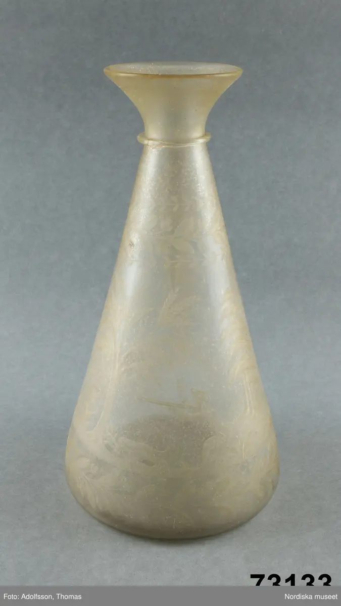 Katalogkort:
" Karaff, graverad. Konisk karaff.
Skogsmotiv med jägare skjutande hjort.Korrosionsprocess relativt långt framskriden. en bit urslagen nedtill".
Se Seitz 1936, pl 33 D.