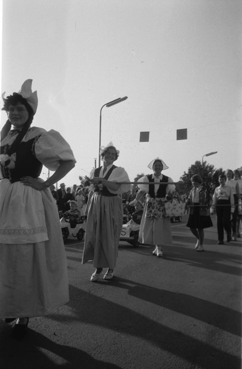 Diverse foto fra Barnas dag. Opptog i byen og aktiviteter på Hamar stadion. Barn og voksne i kostymer, går i tog i Strandgata, Hamar.