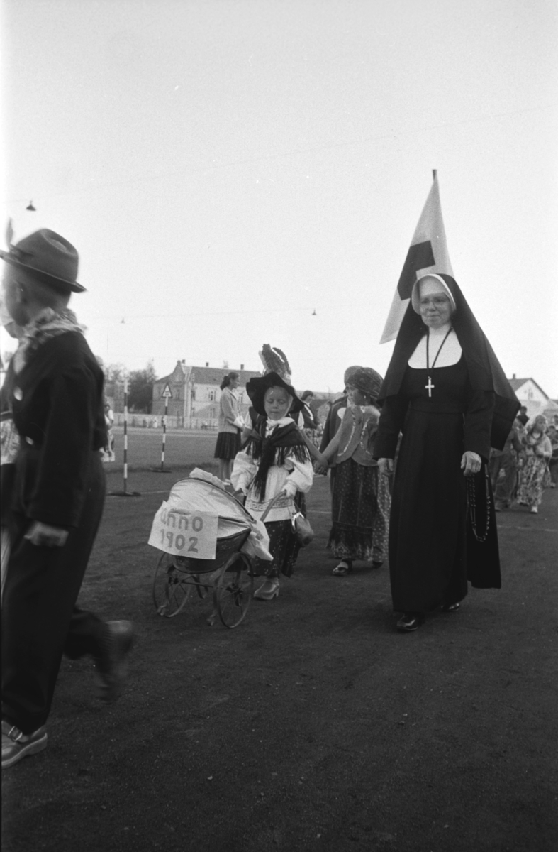 Diverse foto fra Barnas dag. Opptog i byen og aktiviteter på Hamar stadion. Barn i opptog inn på Hamar stadion. En nonne følger barnetoget. St.Torfinn barnehage(?)