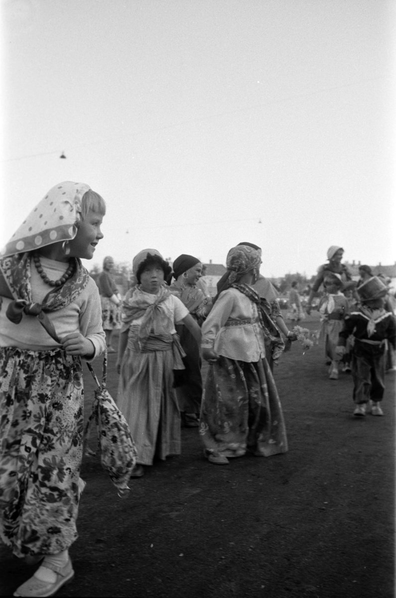 Diverse foto fra Barnas dag. Opptog i byen og aktiviteter på Hamar stadion. Barn i kostymer går i opptog inne på Hamar stadion.