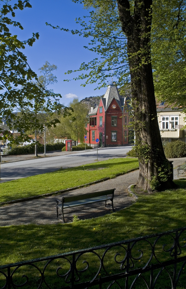 This is the story of how Norway’s most important conversation-space was designed by a young, freshly graduated man from Bergen.

“Norwegian architects are hereby invited…”
In the autumn of 1932, Oslo Telefonanlegginitiated an architectural competition. Finally, Oslo would get its own telephone booth. The city had had so called “talking-stations” from 1885, which in turn were overtaken by automatic telephones 
 only available at selected Narvesen kiosks. The state 
was of the opinion that now was the time to offer the public a better service; public telephone booths open 24/7, like the ones they already had in Sweden and England. But what would they look like, these new telephone booths? What considerations would it
 be necessary to take when designing it? The telegraph board developed a detailed list of demands and restraints: “The booth is intended to be placed outside on the streets and squares and need to be designed so that snow and ice does not hinder the opening and closing of the doors,” they wrote. “To prevent vandalism, theft, uncleanliness etc. inside the booth, it needs to be designed so that from all angles one may see what is going on in there.” Additionally, it would need to withstand storms and bad weather, and “preferably also being whipped by rain mixed with seawater” 

This was not all: The appearance would have to be «pleasing». The booth also needed to be movable, so that it could be taken in to be serviced at Telegrafverket’s main workshops. The reqired material was iron, and the surface was to be spray painted  preferably using car-body paint. There was a requirement for “a writing shelf, a pack shelf, and a suitable place for the telephone catalogue.” Also, there would need to be an illuminated TELEFON  sign, easily visible from all four angles. The total cost for each booth should not exceed 1000 kroner. The first prize for coming up with such a product was 800 kroner.

“Norwegianarchitects are hereby invited to partake in a competition for the design of a telephone booth…”  

The man with the solution
«At some point in 1932, Georg Fredrik sat at a party in Bergen. Maybe he felt a bit lost and forgotten as he often had throughout his life. He retreated to a quiet corner, took out a pencil and strted doodling on a matchbox.  According to my mother, this was how the telephone booth came into being.” In the book “Norges lille røde  historien om telefonkiosken,” Lars Fasting describes his father, the man who is far less known than the iconic architctural structure he left behind. Georg Fredrik Fasting was from Bergen, born into a family of working people and smallholders. One unusual facet of Georg Fredrik was that he was born without ears. His mother made sure he learnt to speak, read and write, 
ut Lars Fasting indicates that his father would seek refuge in drawing when the social challenges became too much to bear. And in the end drawing became his profession. In 1924 he secured a guarantor for a student loan, and started studying to become an a
rchitect at the NTH. Throughout the 1930s he entered several architectural competitions, with drafts produced, according to his son, “after work and in the late hours of the night.”

His efforts were not wasted. Out of 93 entries, with names such as “Flirt”, “Brrr”, “Ring” and “Amor”, the jury selected Fasting’s submission, “RIKS” as the new telephone booth: “The draft shows a strikingly simple solution to the task, technically as well as aesthetically well worked out.”

Taut and provident
Simple and aesthetc are the keywords here. Fasting had designed a booth pointing towards the future, and to modernism. Just how modern it was can be seen by comparing RIKS to the British telephone booth, also designed in the interwar-era. While the British version with it classicistic style is looking back to the heyday of the empire, Fasting’s booth is progressive and functionalistic. Like most Norwegian architects, Fasting broke with the classicistic style of architecture after the Stockholm-exhibition in 1930. “After it, almost all buildings erected in Norway until the German invasion in 1940, were in the functionalistic architectural style,” writes senior curator of architecture at the Norwegian National Museum, Ulf Grønvold, in the book, “Den lille røde”.“TheNorwegian booth is a piece of functionalistic architecture, an asymmetric composition with its roof slab overhanging the word TELEFON, in bold sans seraph lettering,”concludes Ulf Grønvold.

Fashionably red
And it was red. Fasting chose a colour which was part of the modern palette. “A bright red colour, but not as shiny as a signal red, the character of the colour places it among the fashionable colours within functionalism,” states paintings conservator and researcher in NIKU (Norwegian Institute for Cultural Heitage Research), Jon Brænne. In his opinion, Fasting went for visibility without making the booth stand out too much from its surroundings. The original colour was in use up to around 1950, when it changed to signal red. Towards the end of the 1970s the clour was again adjusted towards today’s orangey red.

The design, however, has not changed. RIKS is eighty years and still looks remarkably good. That’s what makes Fasting’s telephone booth a classic  even before it was added to DOCOMOMO’s list over moden icons of design. For Telenor, the telephone booth has served as a pathway into the hearts of the public. For many, Telenor (Televerket) was synonymous with exactly this telephone booth, because this was where one would go to place a call. Having a home
phone was not common until the 1980s. As such the red box became part of the Norwegian everyday and consciousness. The symbol- and publicity value of this is hard to evaluate, but in 2007 it was time to give honour where honour was due, Telenor, in consul
tation with the Directorate for Cultural Heritage, decided to preserve 100 telephone booths for all eternity.

And what about Georg Fredrik Fasting? What happened to him? At the age of 56 an entry in his diary states: «I CAN HEAR». As the first person in th world he had undergone an operation where he had ear canals constructed and eardrums fitted. For the rest of his life, the man behind Norway’s own telephone booth could answer the telephone himself.

Source: Norges lille røde historien om telefonkiosken (2007), issued by The Norwegian Telecom Museum and Telenor Cultural Heritage.