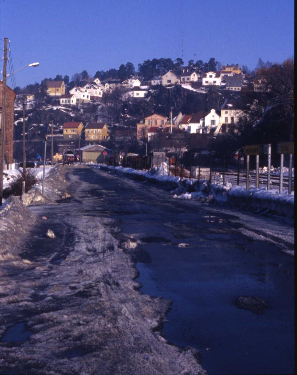 Jernbanelinjen går langs Ytre Strandvei, februar 1982. I bakgrunnen ser vi noe av bebyggelsen på Tangheia.