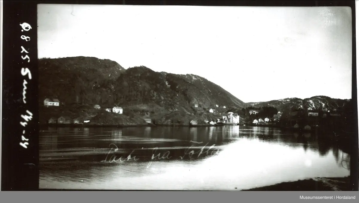 Bilde av Fotlandsvåg. Klar fjord, med bedriftsbygning og flere småbygg omkring. Område omringet av fjell.