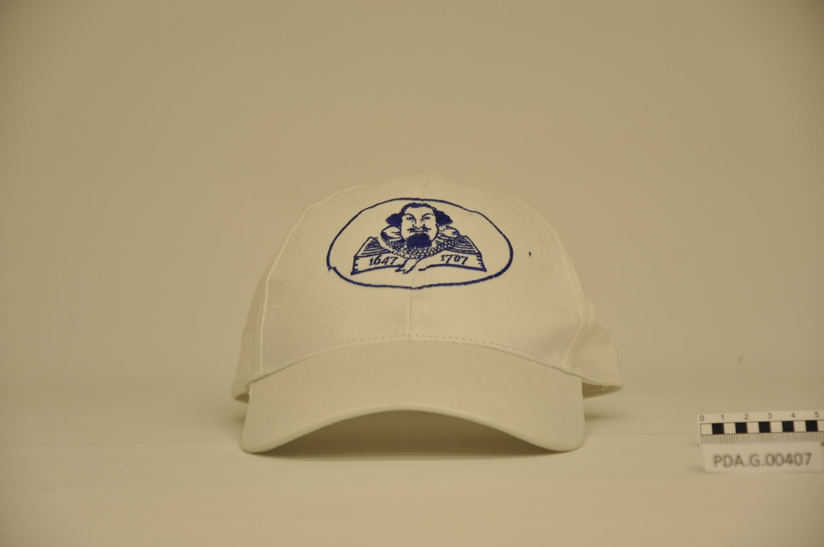 Petter Dass med prestekrage, over en bok.