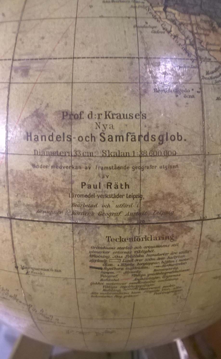 Jordglob från pansarskeppet VICTORIA. Vridbart klot kring en lutad axel. Mässingsstativ på svarvad fot med fotplatta. Limmad tappglob.