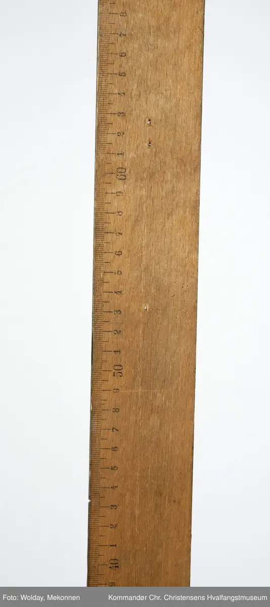 Form: T-form, lang linjal med cm-skala. Rundt hull i enden