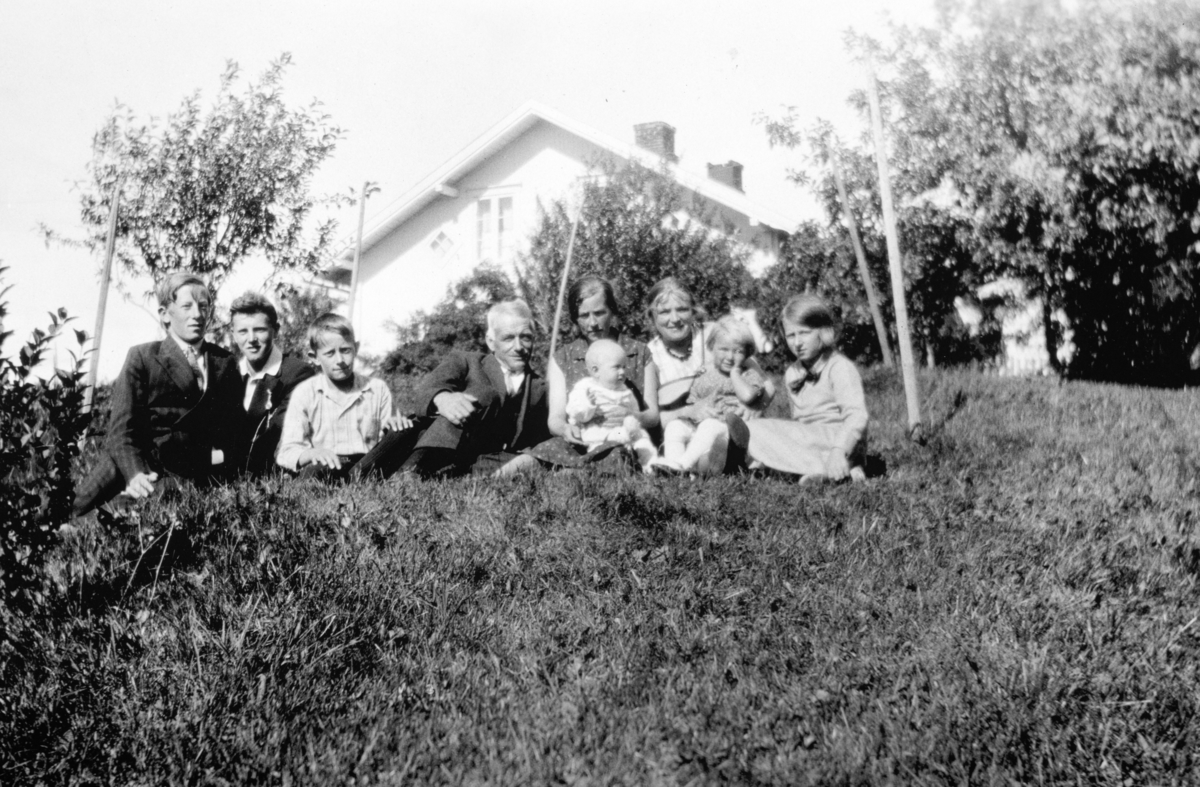 Hele familien på Søndre Tomter (Ner-Tomter) samlet i hagen i 1932. F.v: Leif, Gudmund, Kåre, Jacob, Helga med Harald, Inga Tomter fra Dokka (gift med Sigurd Tomter som tar bildet), Marta og Signe.