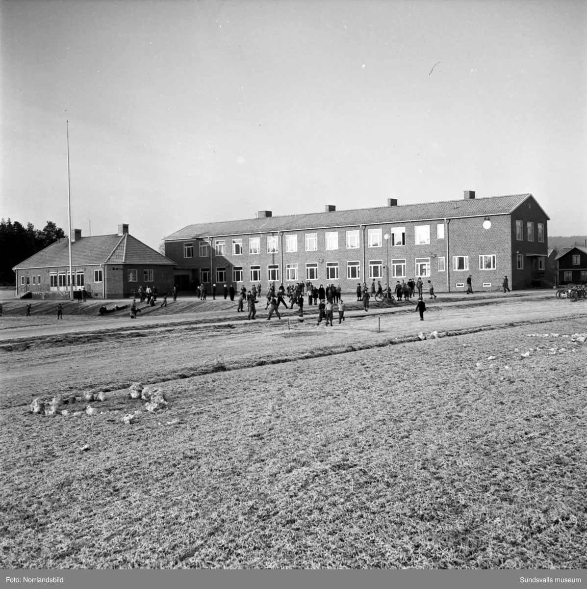 Reportagebilder från Stöde skola, tidigare Slättåbygdens skola. Exteriör, interiör, lektioner i klassrummen, rastlek, elever, personal, lärarrum och affischförråd. Bild 2: busschauffören är Jonas Malmgren. Bild 8: Harry Wiberg. Bild 9: Maritta Larsson. Bild 12: vaktmästare Adrian Almgren. Bild 14: Johan Näsström. Bild 15: Lärarrummet med: Längst bak från vänster Karin Jonsson, Linnea Sterner, Roland Källsäter och Johan Näsström. Längst fram sitter Märta Näsström och Hildegard Svensson.