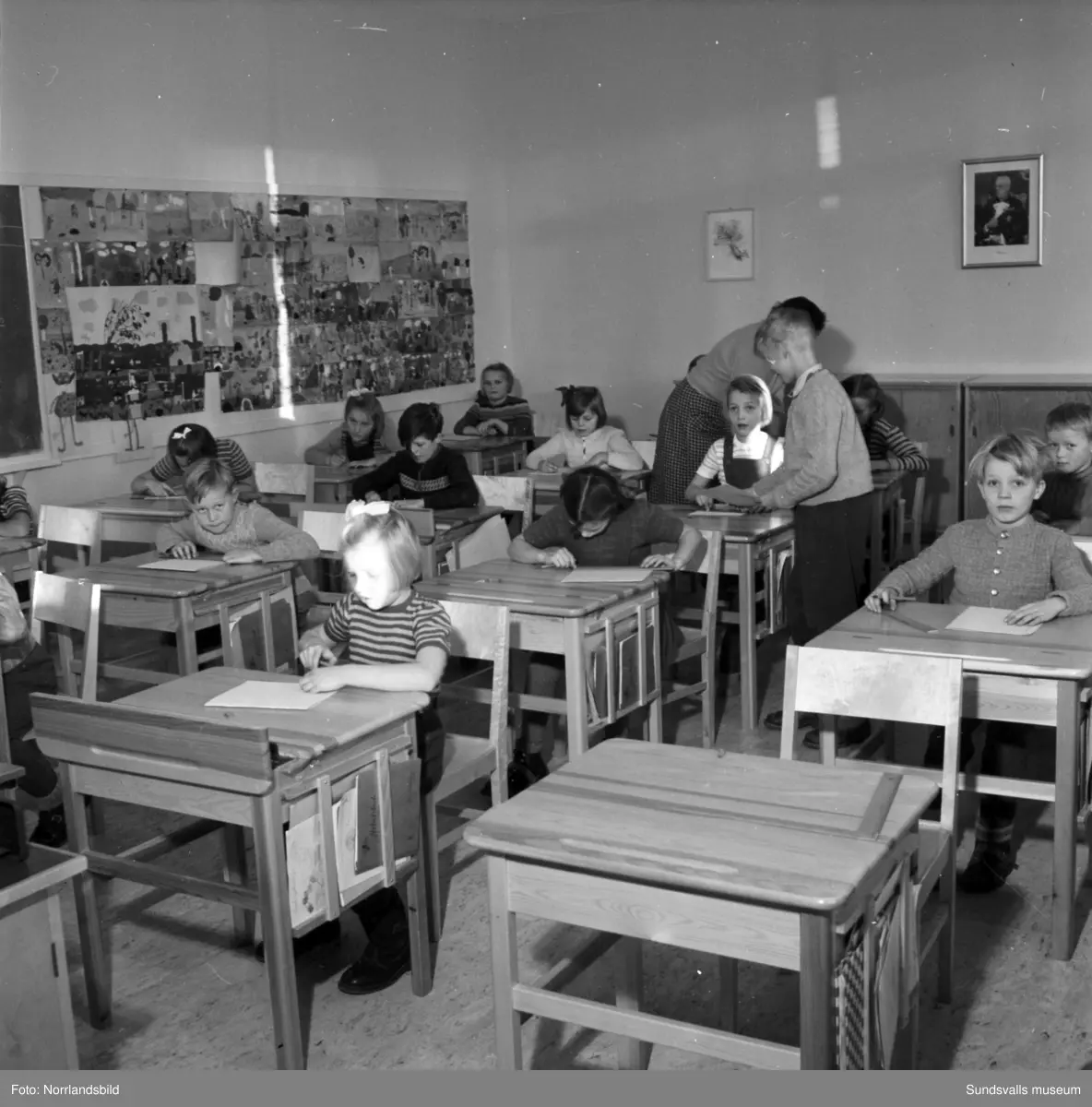 Reportagebilder från Stöde skola, tidigare Slättåbygdens skola. Exteriör, interiör, lektioner i klassrummen, rastlek, elever, personal, lärarrum och affischförråd. Bild 2: busschauffören är Jonas Malmgren. Bild 8: Harry Wiberg. Bild 9: Maritta Larsson. Bild 12: vaktmästare Adrian Almgren. Bild 14: Johan Näsström. Bild 15: Lärarrummet med: Längst bak från vänster Karin Jonsson, Linnea Sterner, Roland Källsäter och Johan Näsström. Längst fram sitter Märta Näsström och Hildegard Svensson.