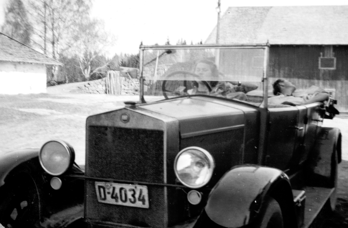 Marta H. Tomter «prøvekjører» Fiat’en på Søndre Tomter (Ner-Tomter) ca. 1950. Brødrene hennes Gudmund og Leif hadde sertifikat til å kjøre bilen. Faren deres, Jacob Tomter eide bilen, men tok aldri sertifikat selv.