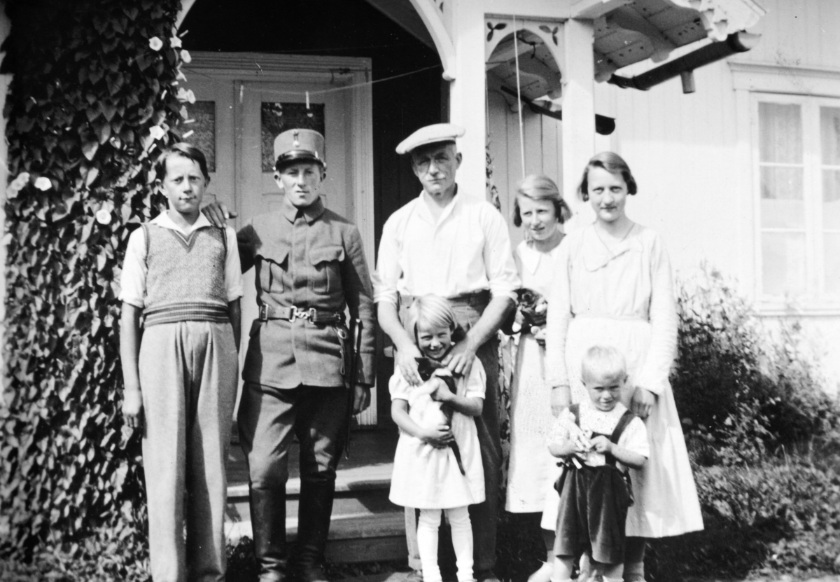 Foran verandainngangen på Søndre Tomter (Ner-Tomter) ca. 1935. F.v: Kåre, Leif (i uniform), Jacob med Marta, Signe (bak), Ingrid Evensen(?) med Harald foran seg.