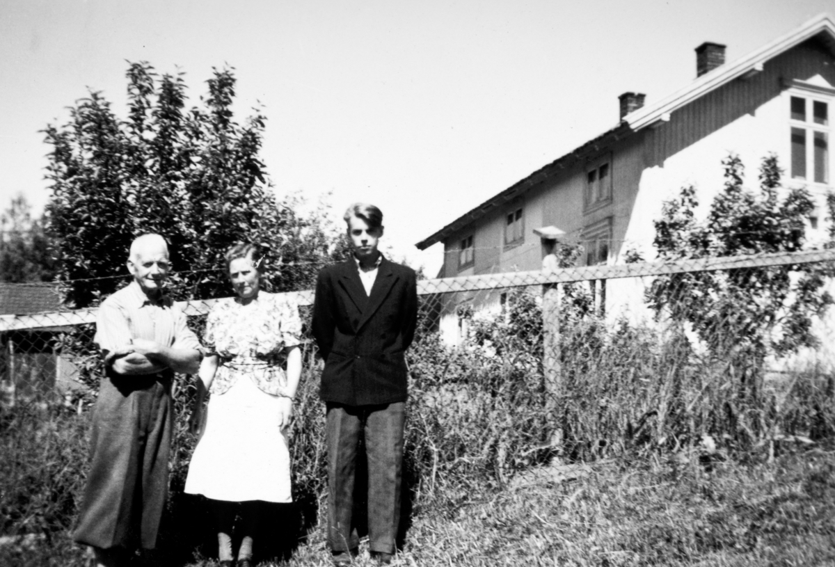 Jacob, Helga og sønnen Harald M. Tomter utenfor hagegjerdet på føderåden på Søndre Tomter (Ner-Tomter) ca. 1950.