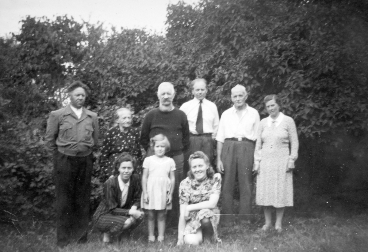 Fra hagen på Søndre Tomter (Ner-Tomter) på 1930-tallet. F.v. foran: Olga Slæperud, Marta H. Tomter,?. Bak f.v: ?, Dina og Ole Slæperud, Lars Slæperud, Jacob og Helga Tomter. Dina og Ole leide husrom på føderåden, barna deres Lars og ukjent er på besøk fra Oslo