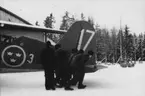 Flytt av flygplan S 17 på skidor, på F 3 Östgöta flygflottilj, vintertid 1946. Fem män i arbete vid flygplansstjärt.