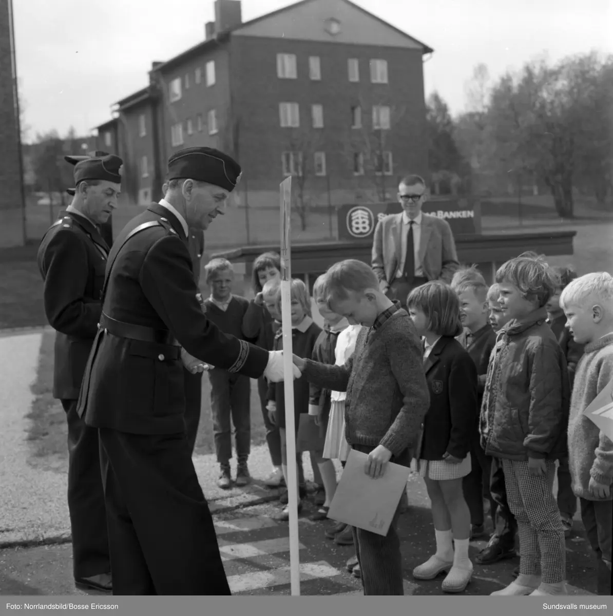 Poliserna Bengt Resare och Evald Börjesson delar ut diplom på avslutningen vid trafiklekskolan i Sundsvall.