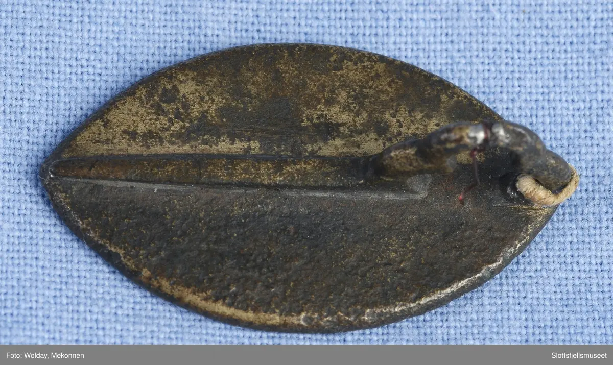 Spissoval form og innenfor omskrift står en kronet skikkelse som holder et hjul eller lignende. Bedende person nederst, muligens en munk.